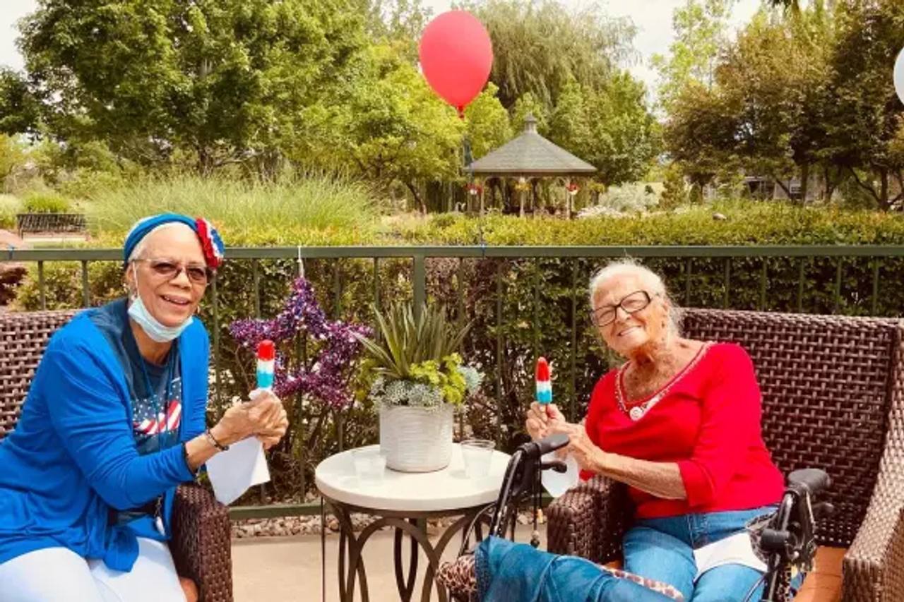 Two Gardens at Columbine residents enjoying drinks on a garden patio