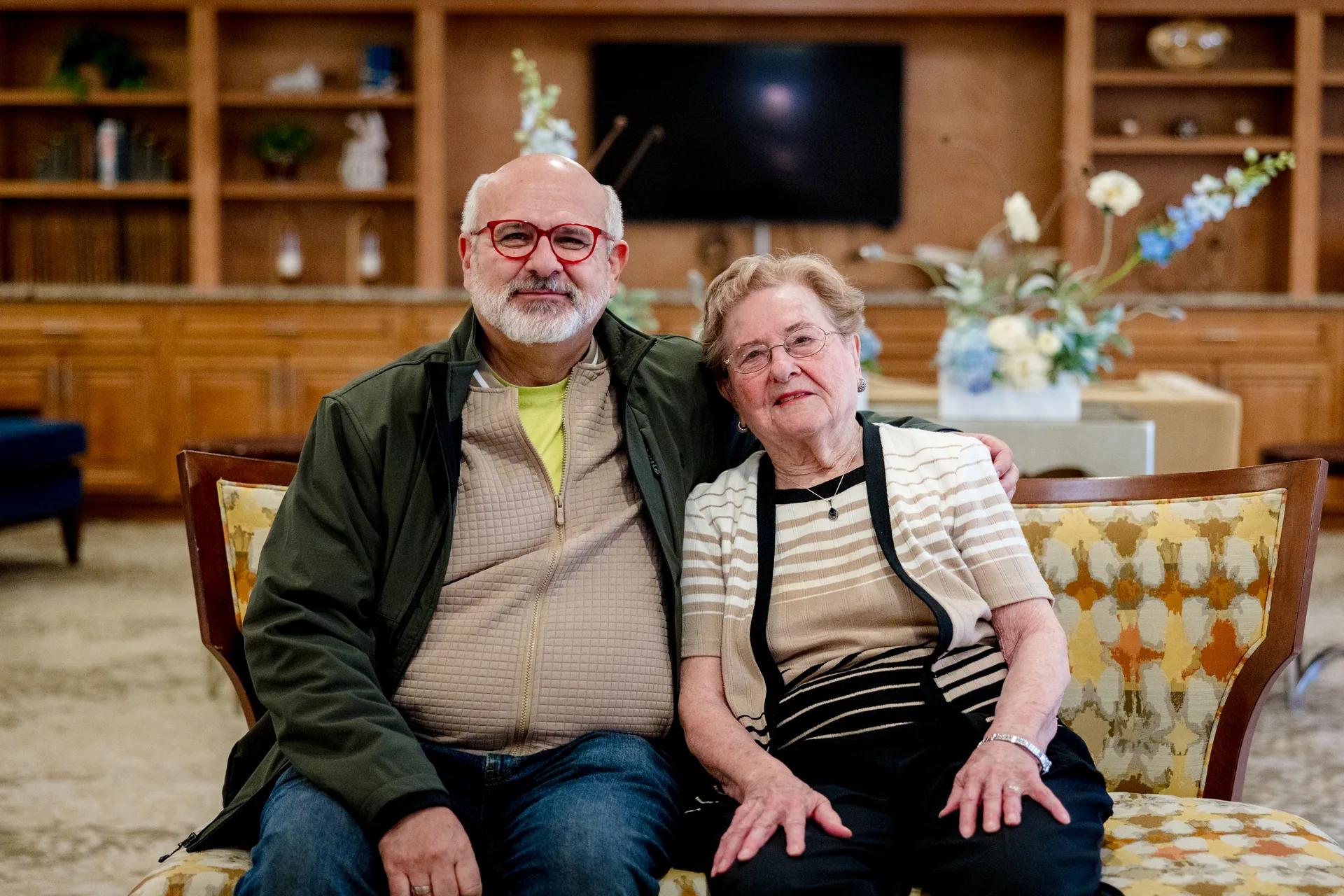 Stonebridge Senior resident and visitor seated together in a community lounge