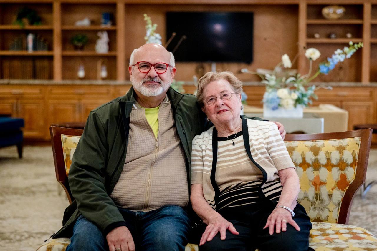 Stonebridge Senior resident and visitor seated together in a community lounge