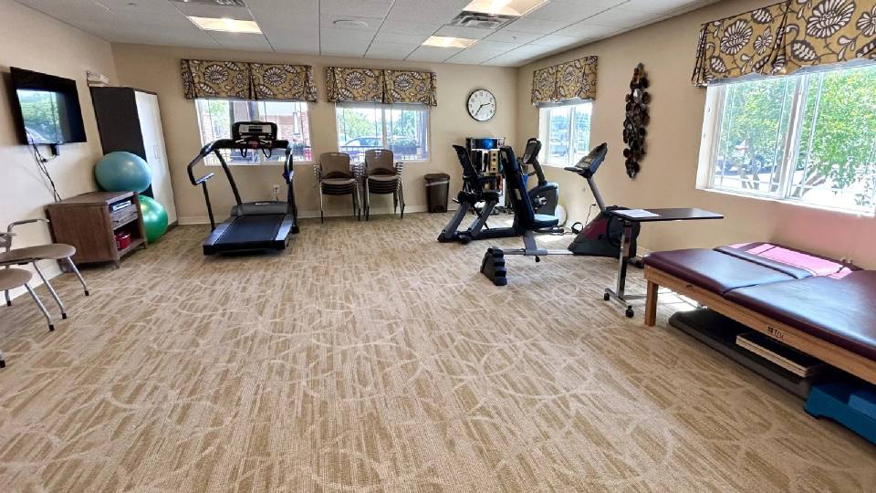 Stonebridge Senior rehabilitation room with exercise equipment and therapy table