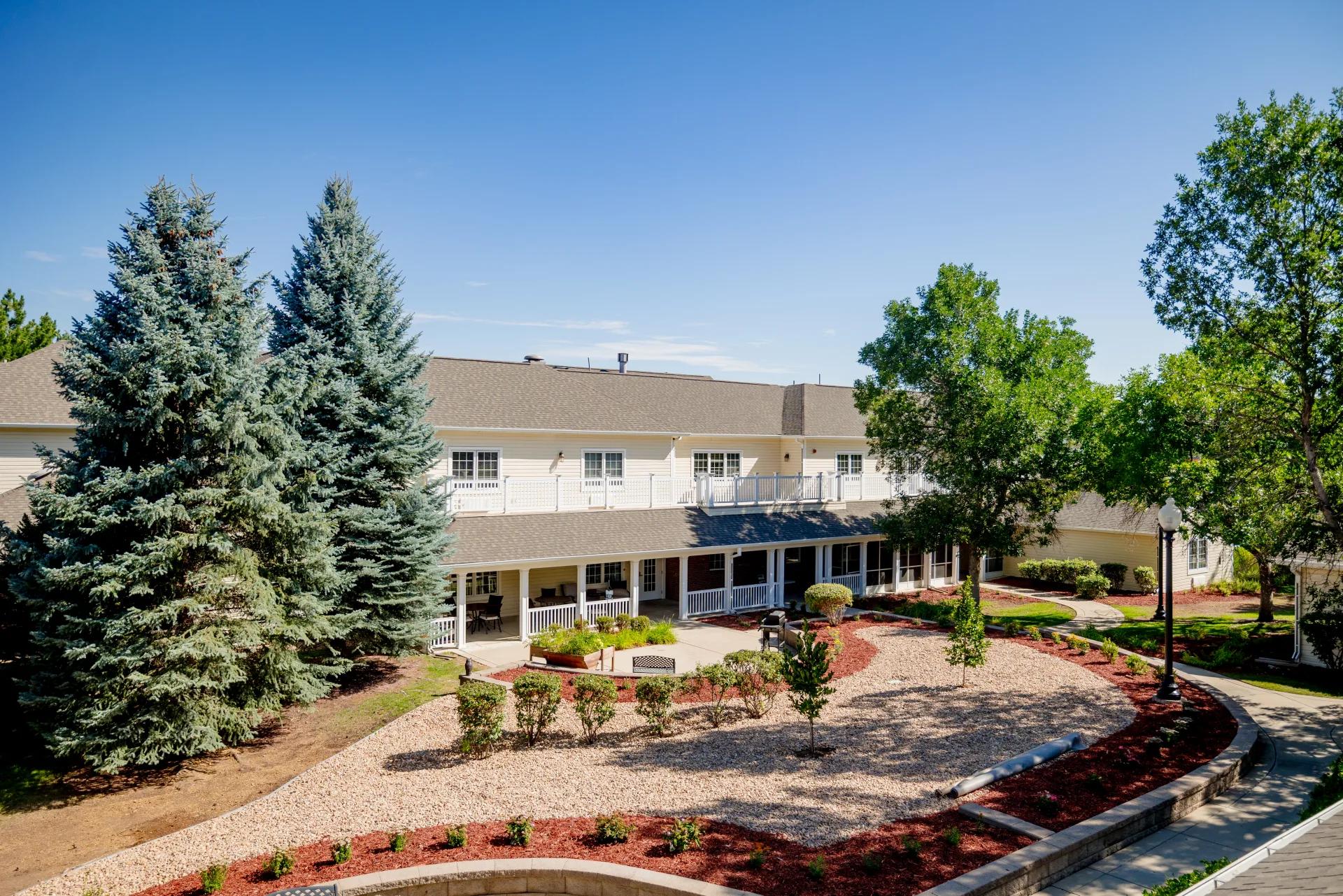 Bear Creek courtyard with landscaped beds, walking paths, and a covered building wing
