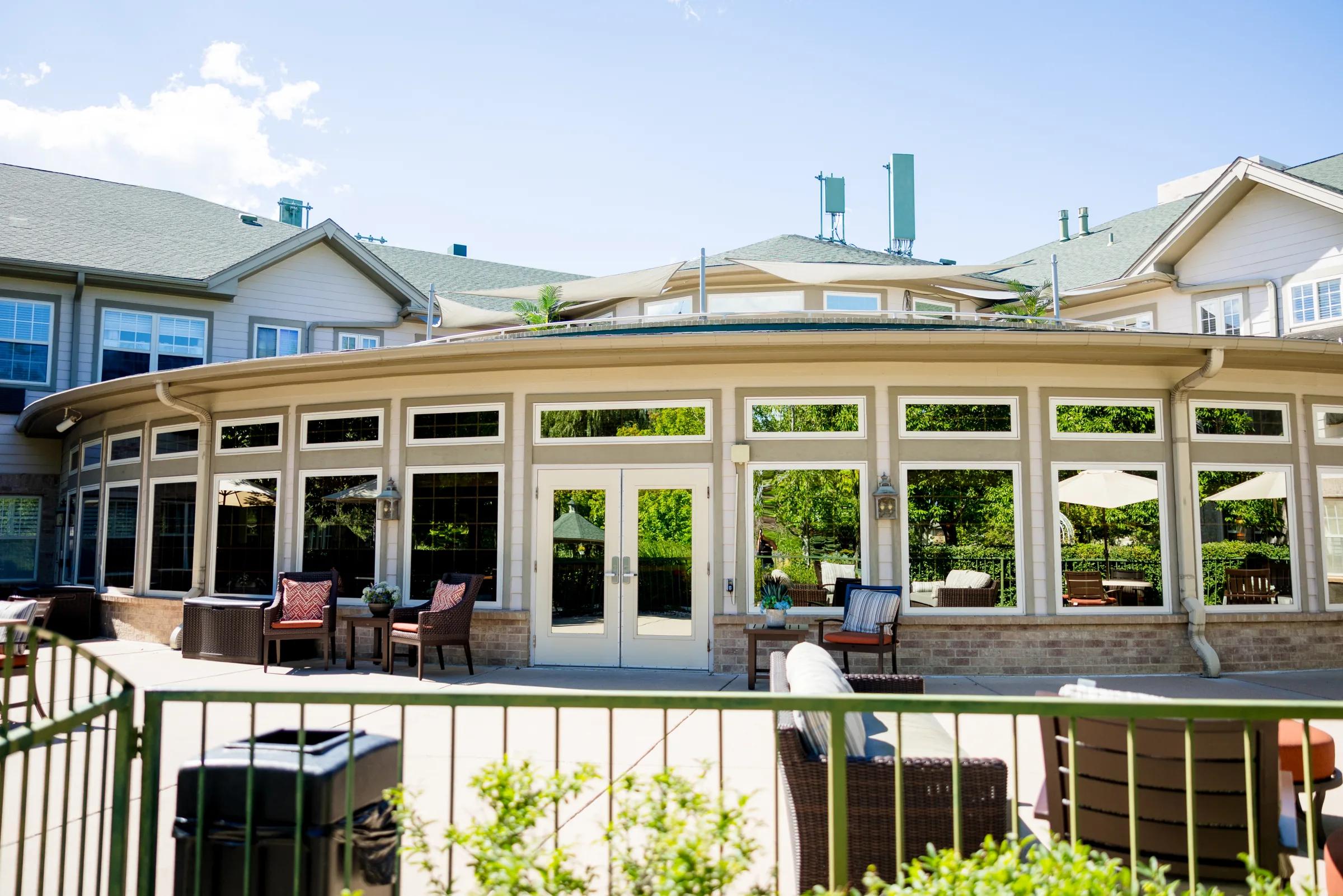 Gardens at Columbine back exterior showing the conservatory patio doors and seating
