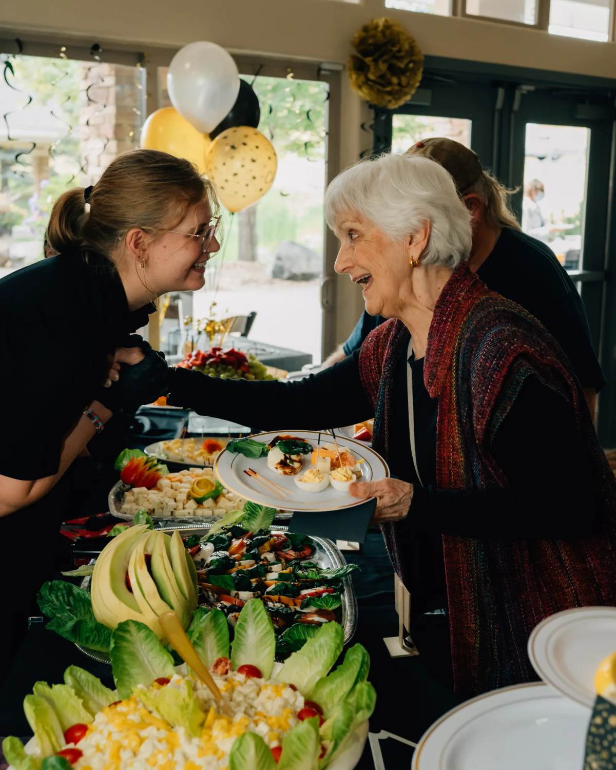 Golden Pond staff member laughing with a resident at the event buffet