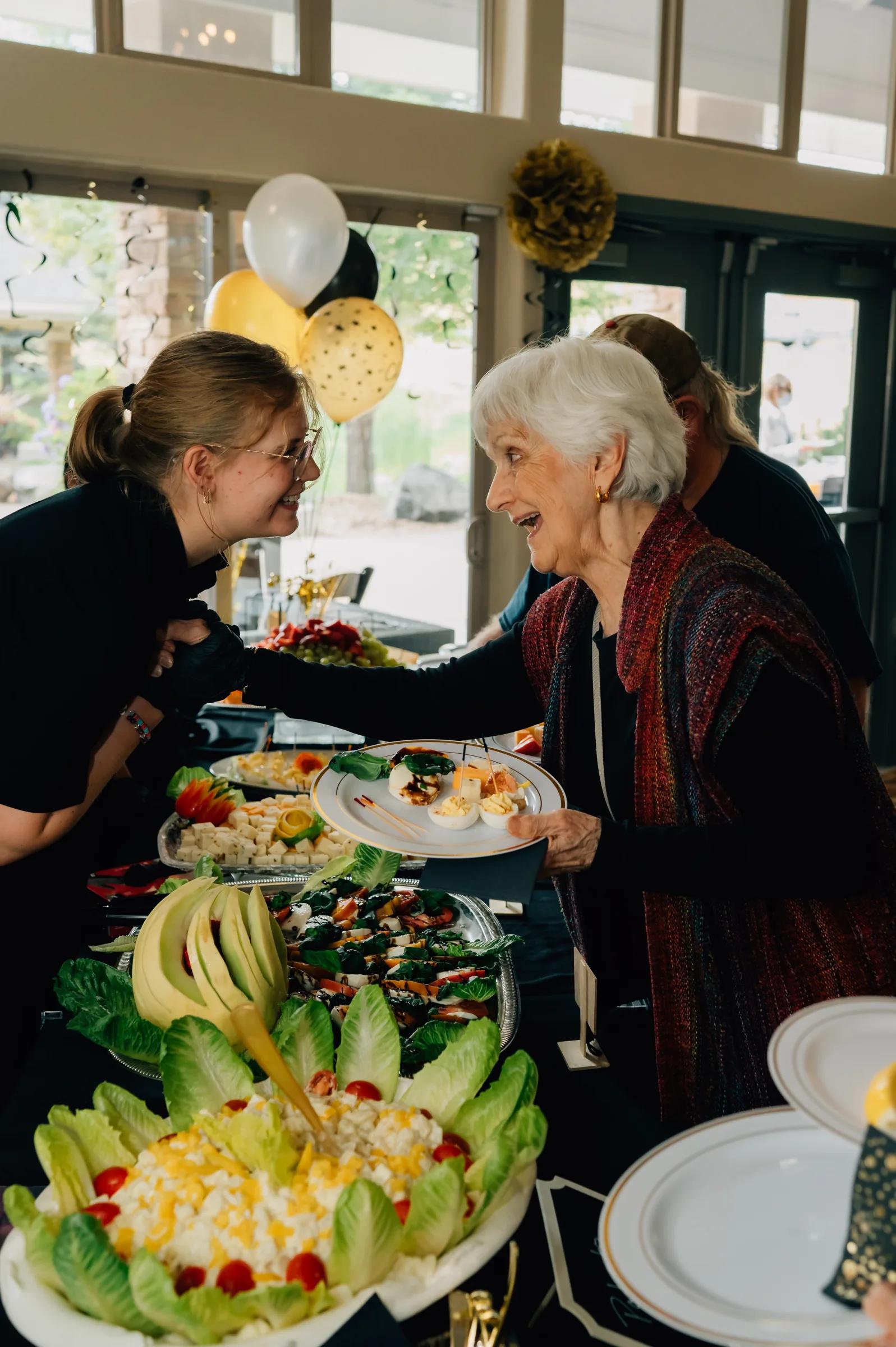 Golden Pond staff member laughing with a resident at the event buffet