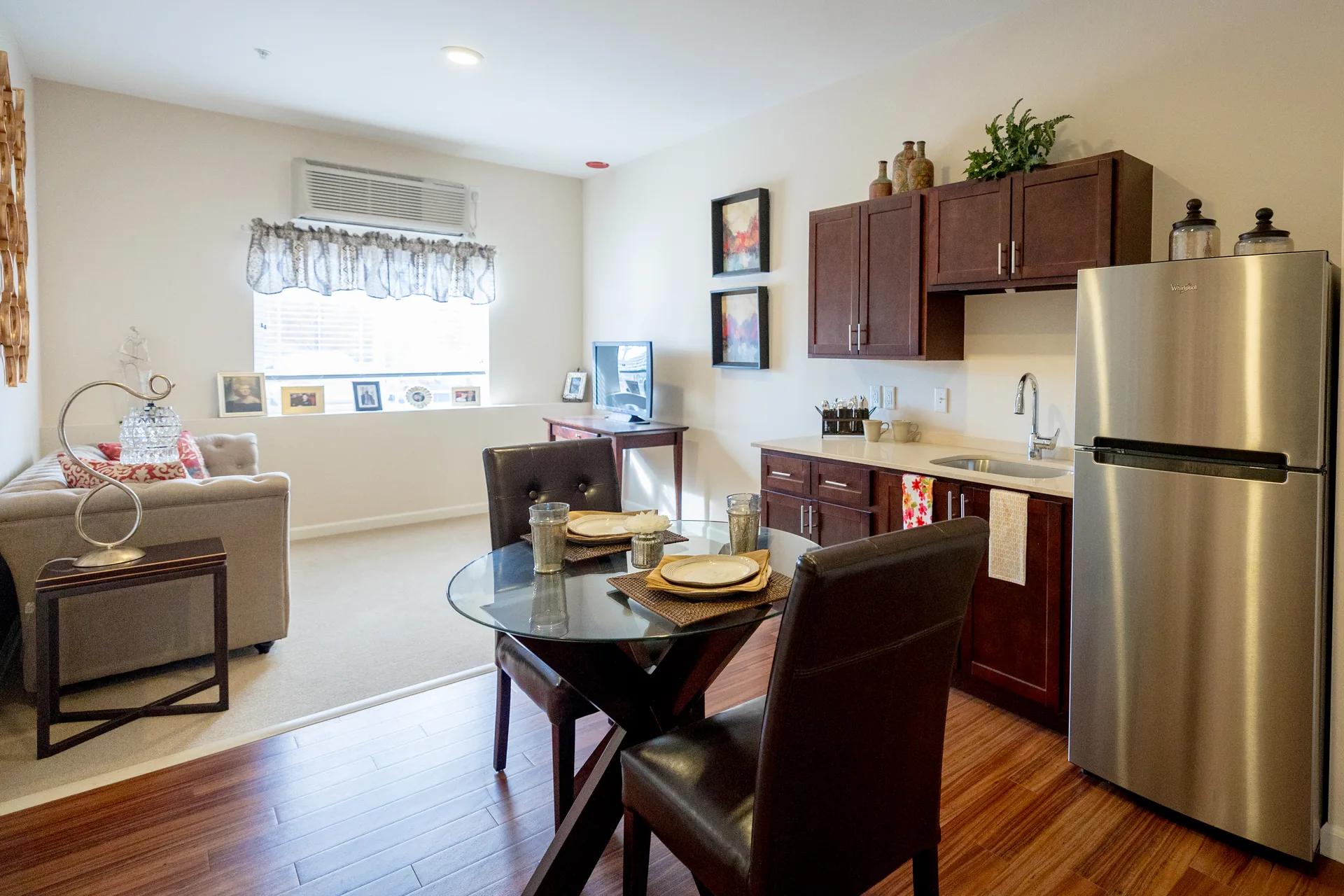 Stonebridge Senior apartment kitchenette, dining table, and living area