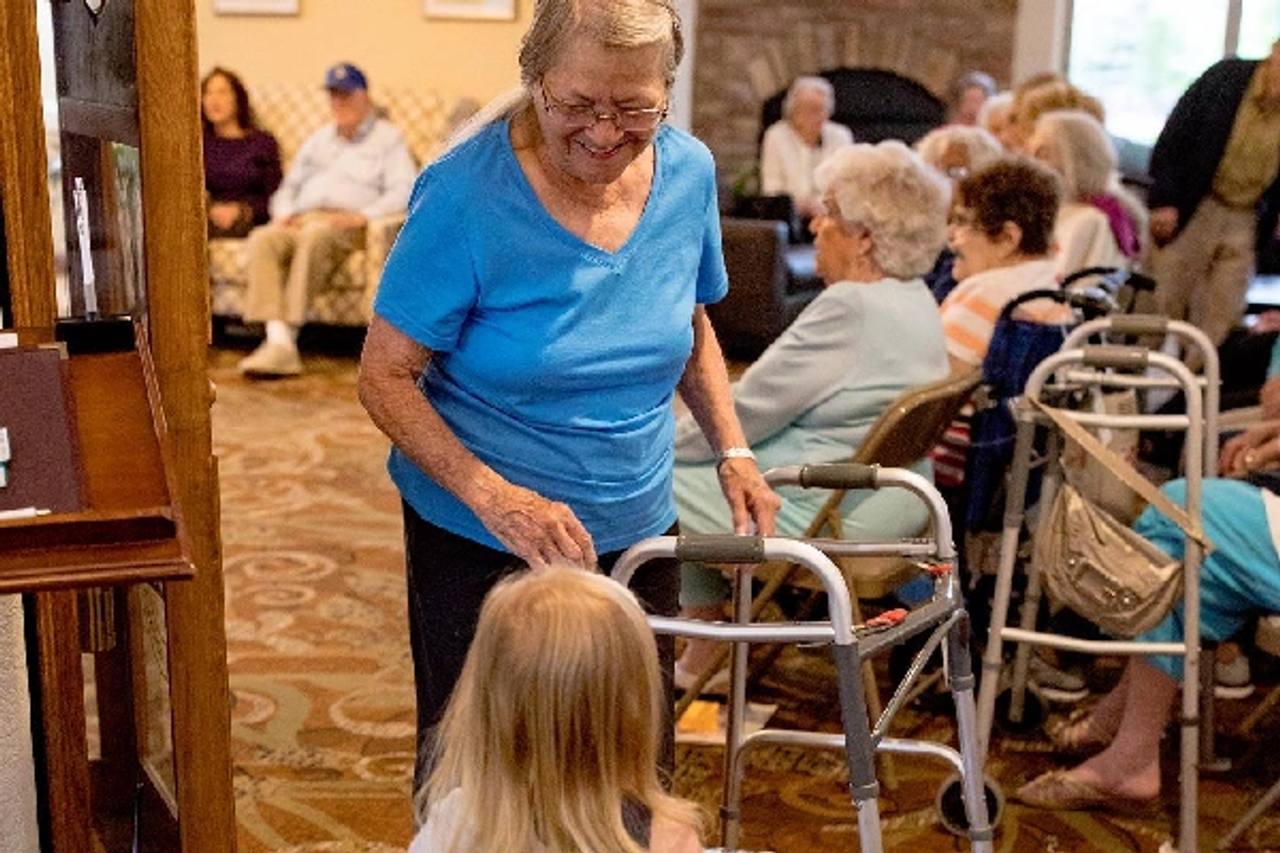 Golden Pond resident walking with a walker during a community gathering