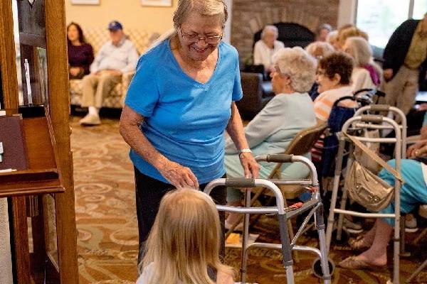 Golden Pond resident walking with a walker during a community gathering