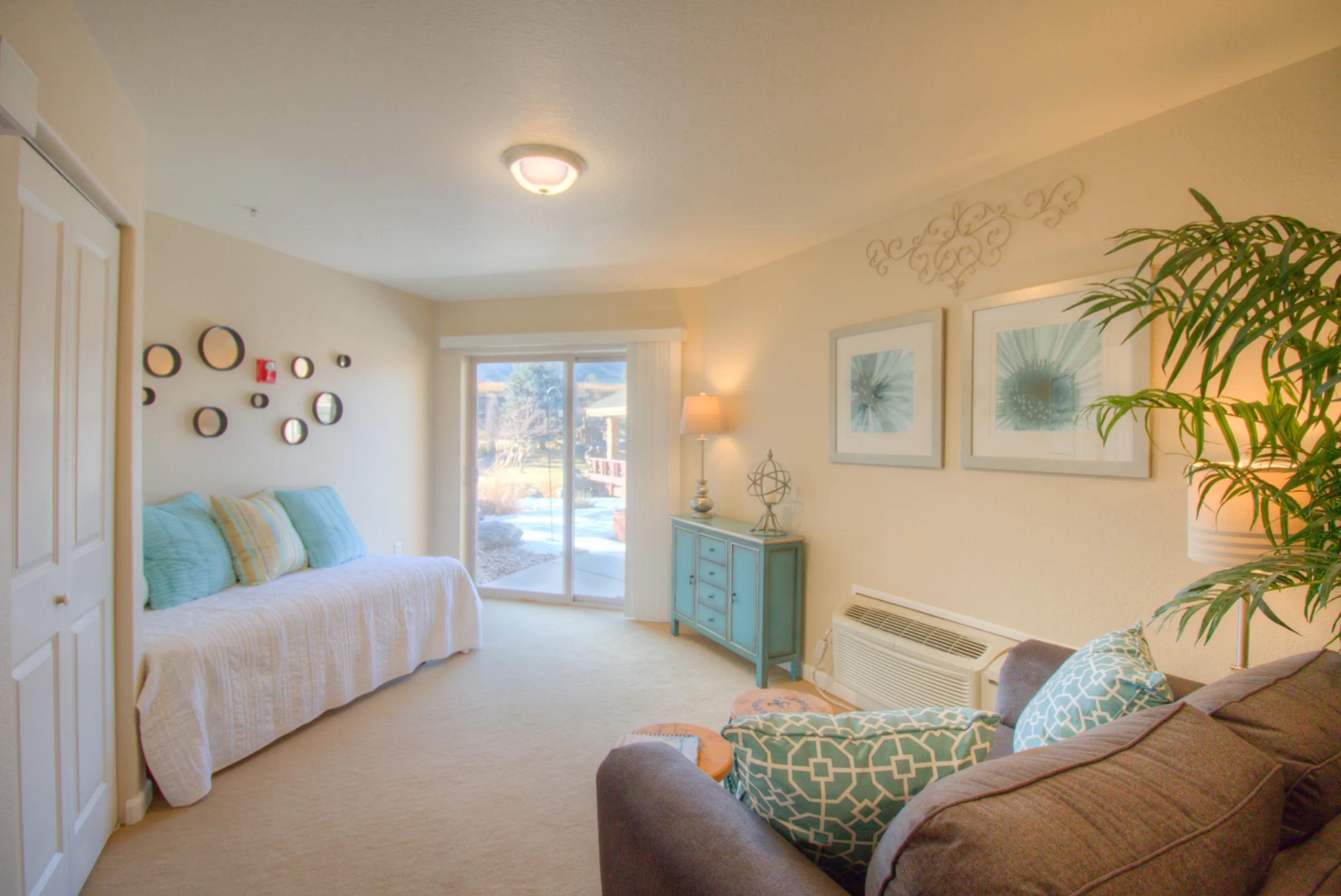 Golden Pond apartment den with daybed, plate wall decor, and sliding door to patio