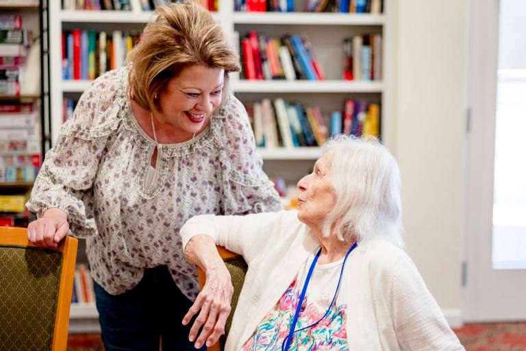 A Gardens at Columbine team member speaking with a resident.