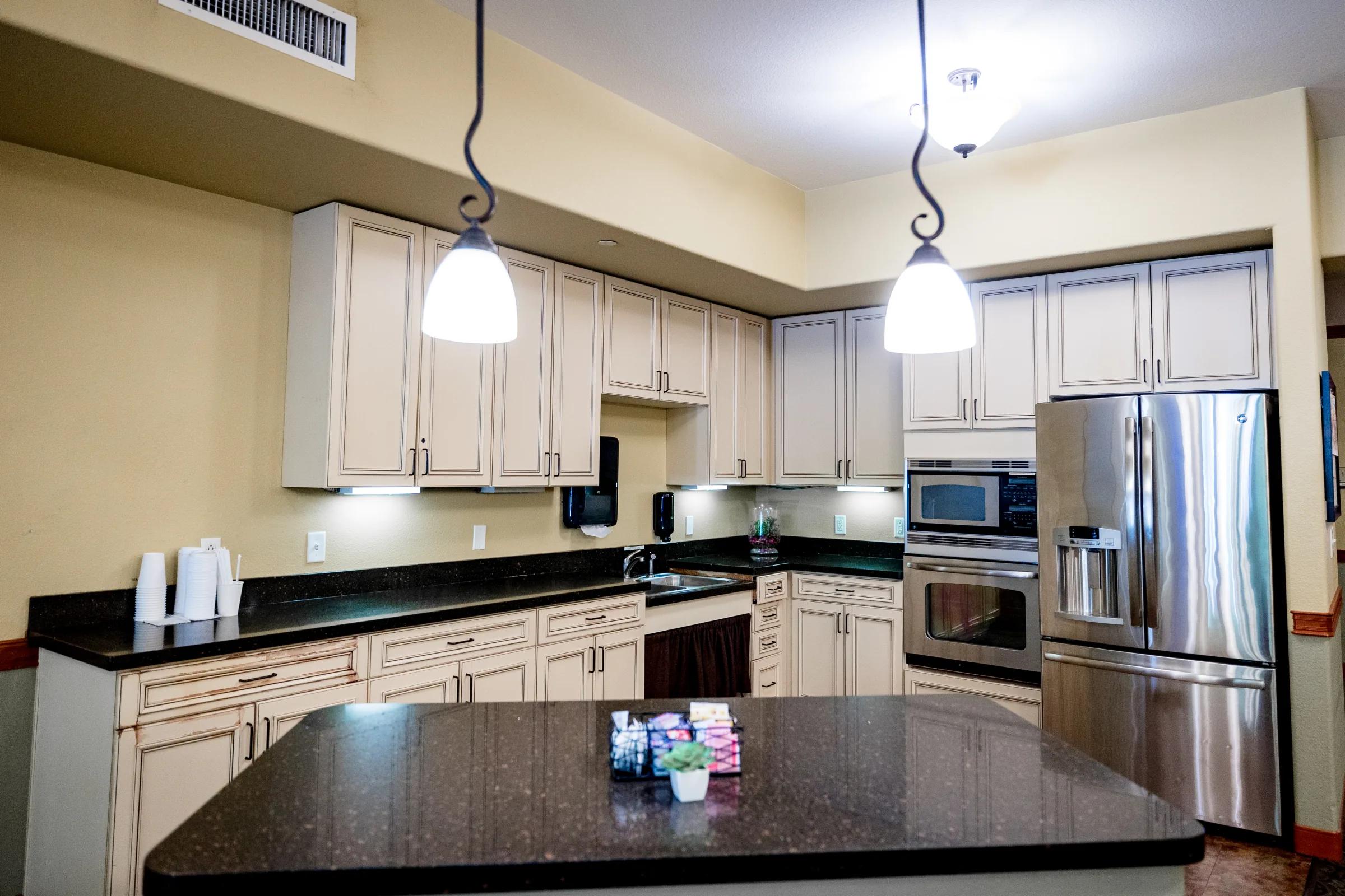Gardens on Quail community kitchen with stainless appliances and granite island