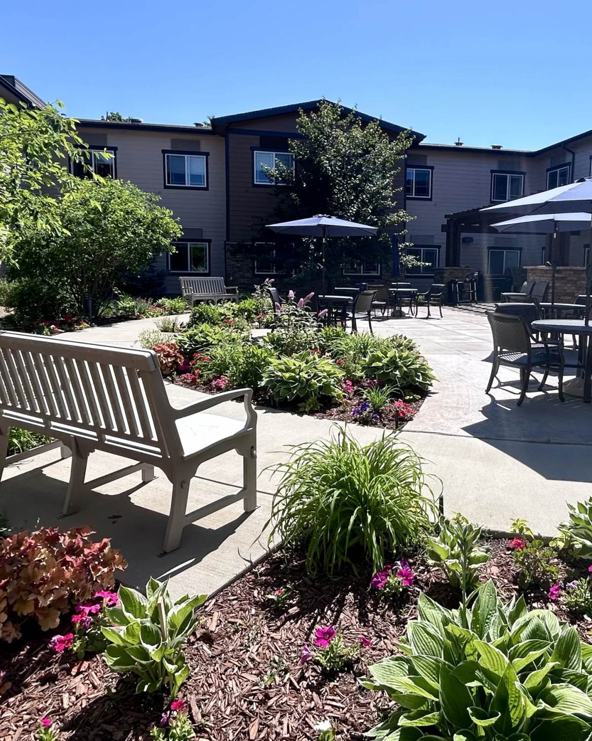 Stonebridge courtyard garden with bench and umbrella patio seating