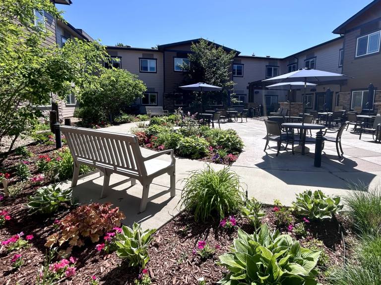 Stonebridge courtyard garden with bench and umbrella patio seating