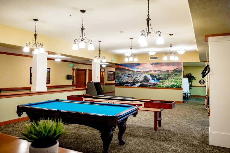 Gardens on Quail billiards room with pool table, shuffleboard, and Colorado mural