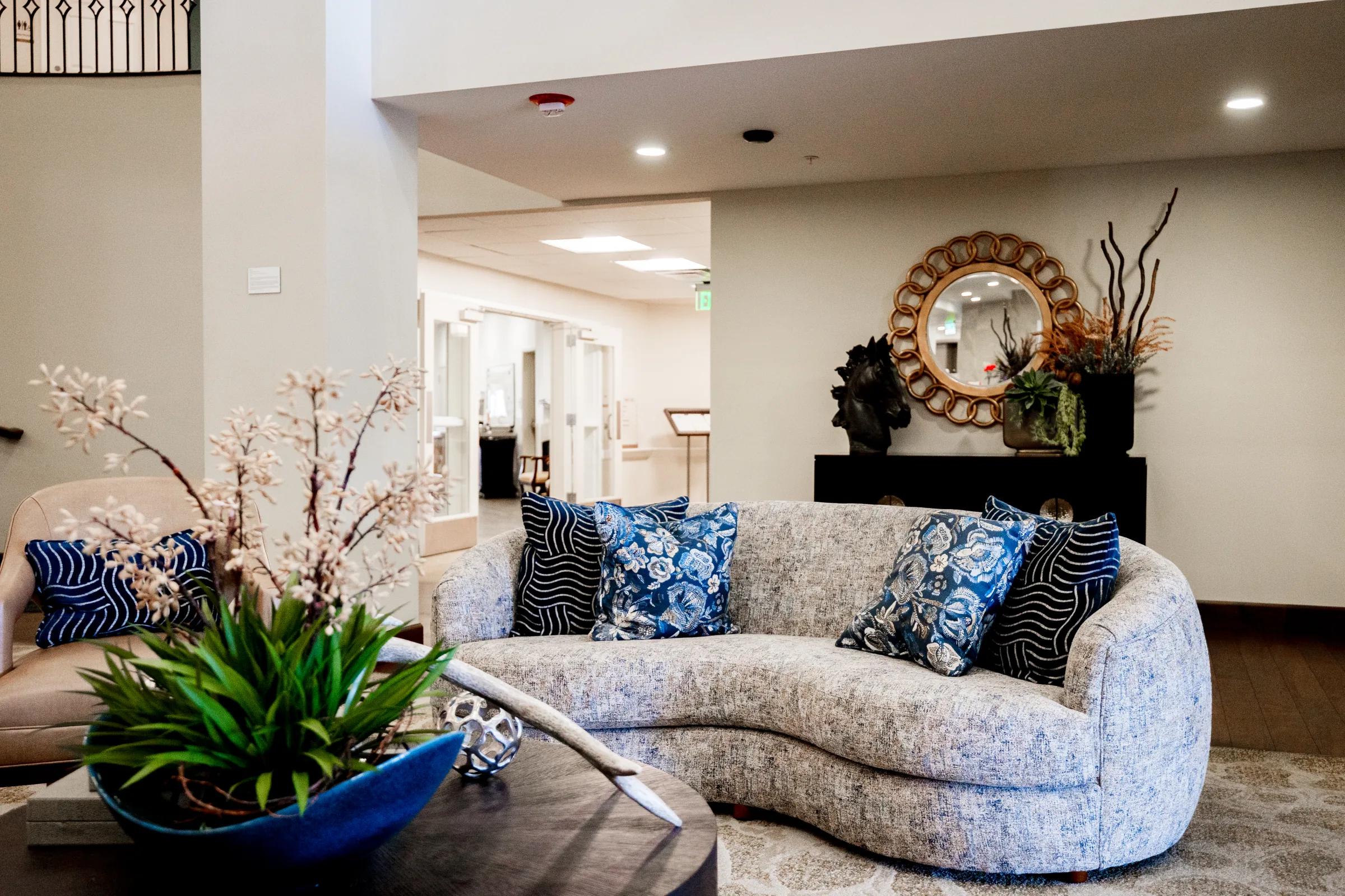 Curved gray sofa with patterned accent pillows in a Stonebridge sitting area