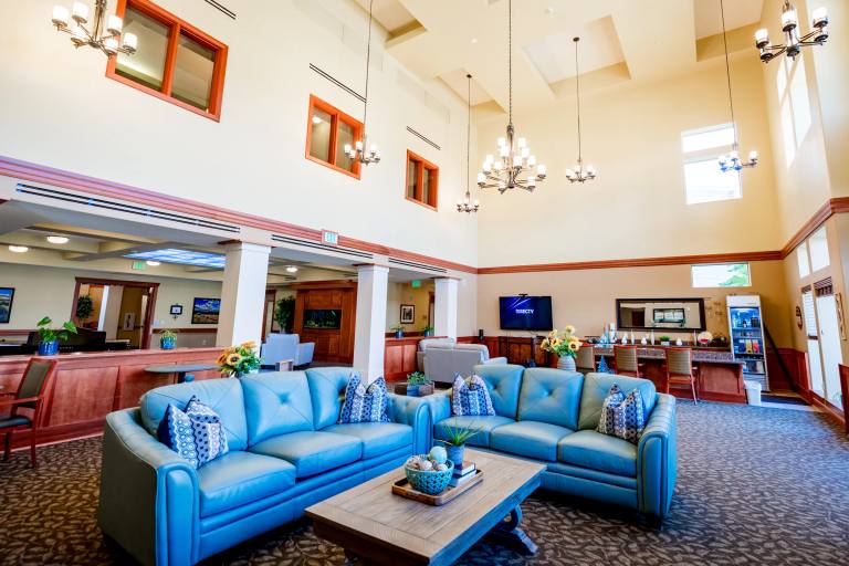 Gardens on Quail main lobby with twin blue leather sofas and cathedral ceiling