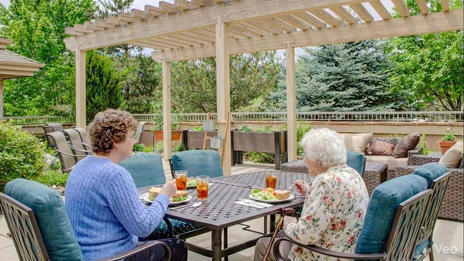 Two people sharing lunch on the Golden Pond patio beneath a pergola