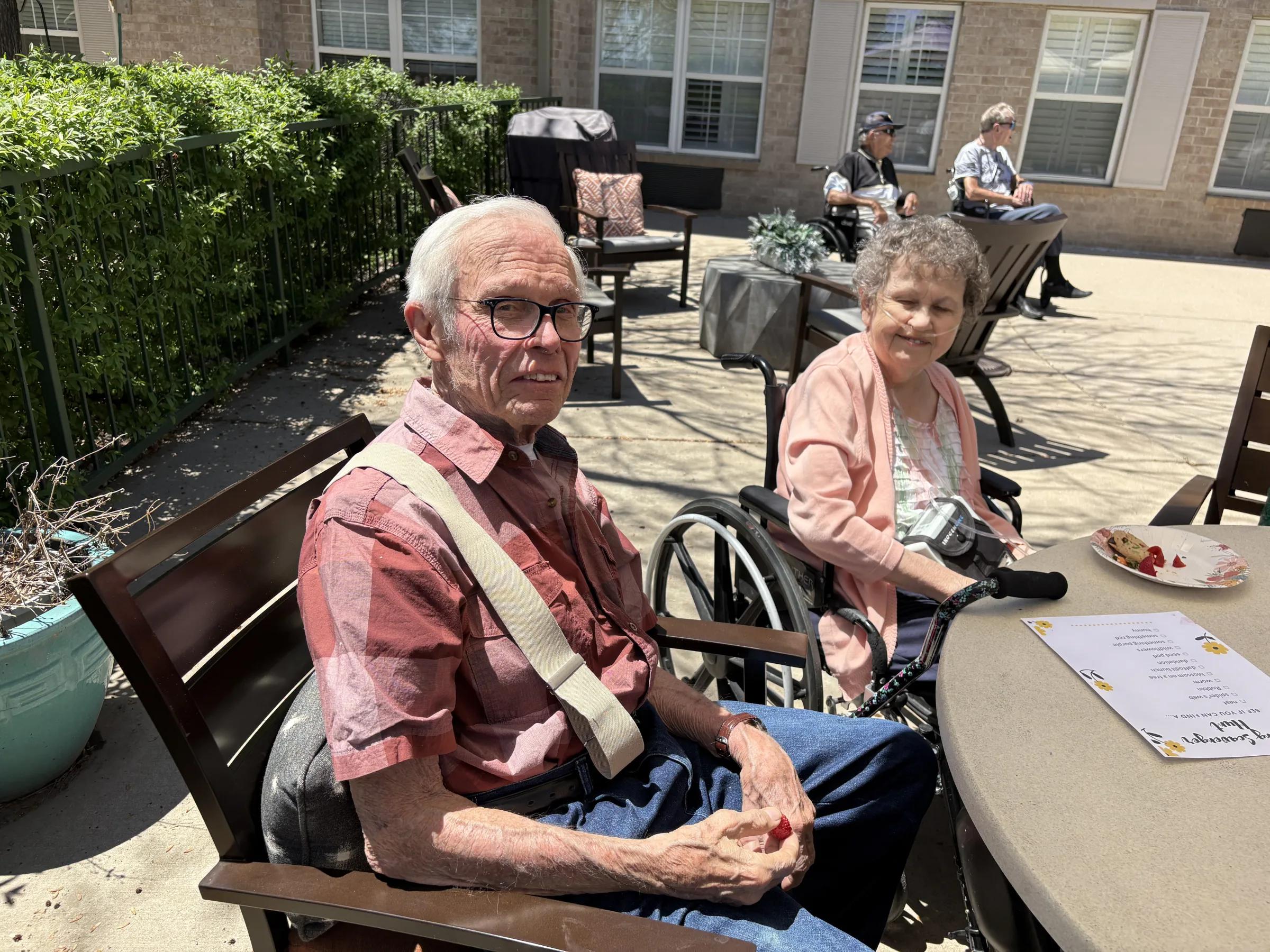 Gardens at Columbine resident visiting with family member on the sunny patio