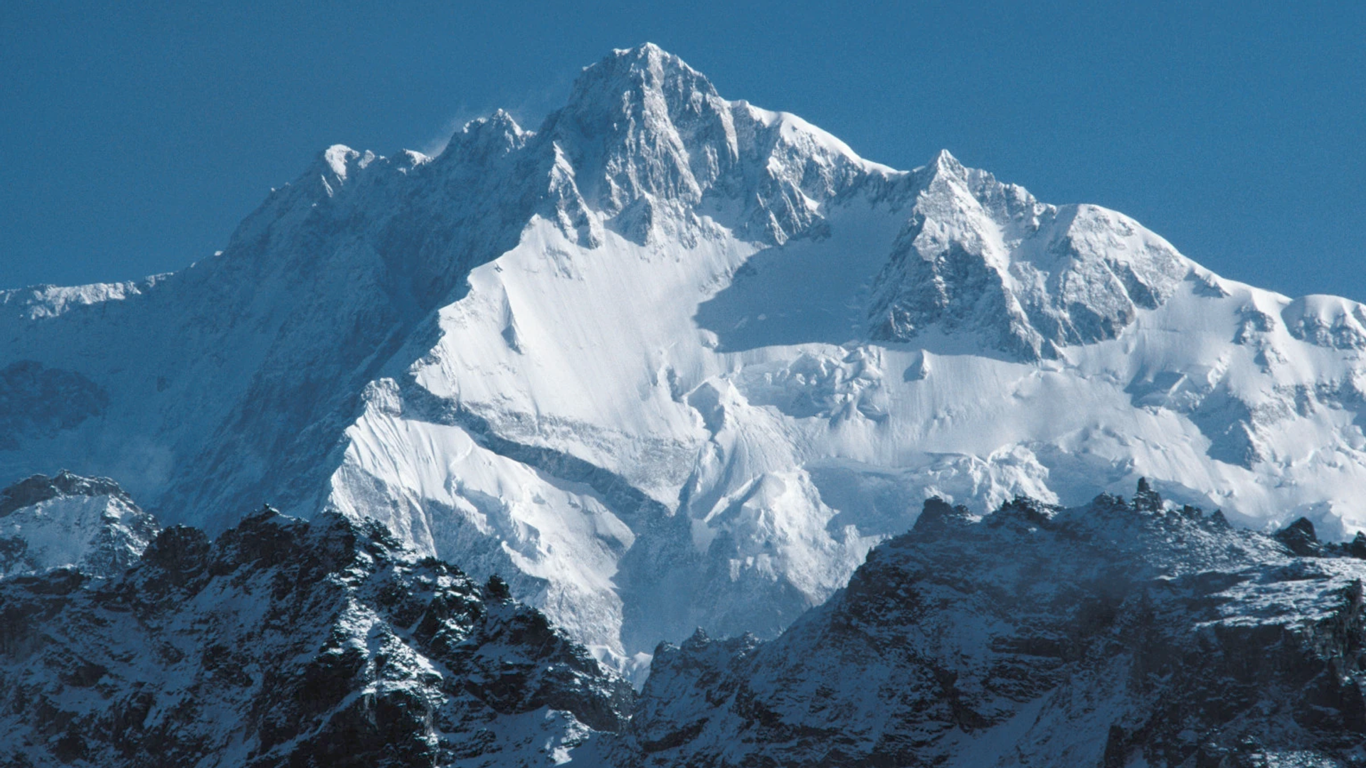 Mount Kangchenjunga snow peak with Buddhist monastery and prayer flags above Sikkim Himalayan valley