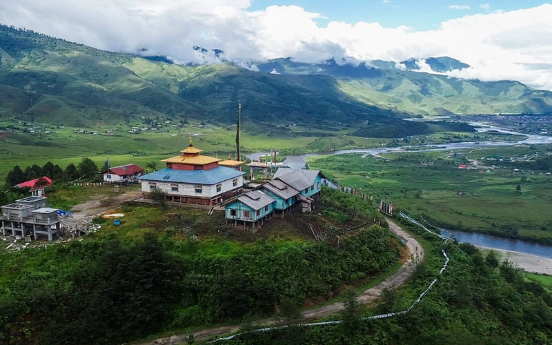 Alt-Text: > A panoramic view of the eco-friendly bamboo stages at the Ziro Valley Music Festival 2026 in Arunachal Pradesh, surrounded by the UNESCO-recognized Apatani terraced rice fields.