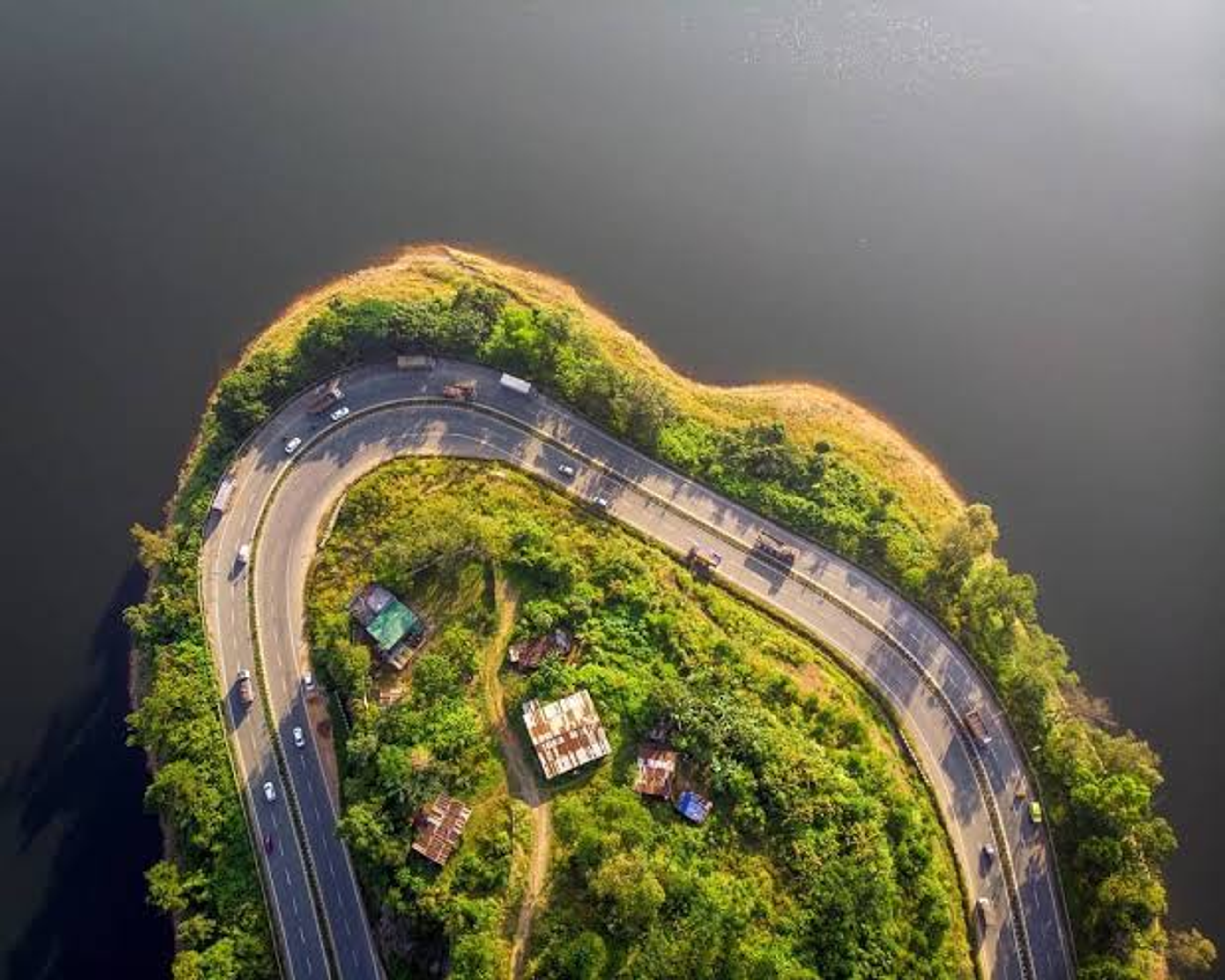 Line of cars on a hill road near Umiam Lake on the way to Bhoirymbong at dusk