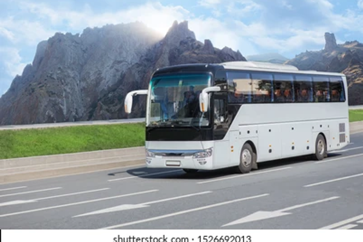 An air conditioned state transport corporation luxury tourist bus driving smoothly along a mountain highway curve