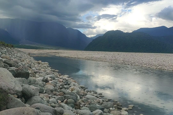 Panoramic view of the turquoise Dibang River flowing through massive white boulders at Nizamghat, showcasing the raw beauty and top things to do in Roing, Arunachal Pradesh.