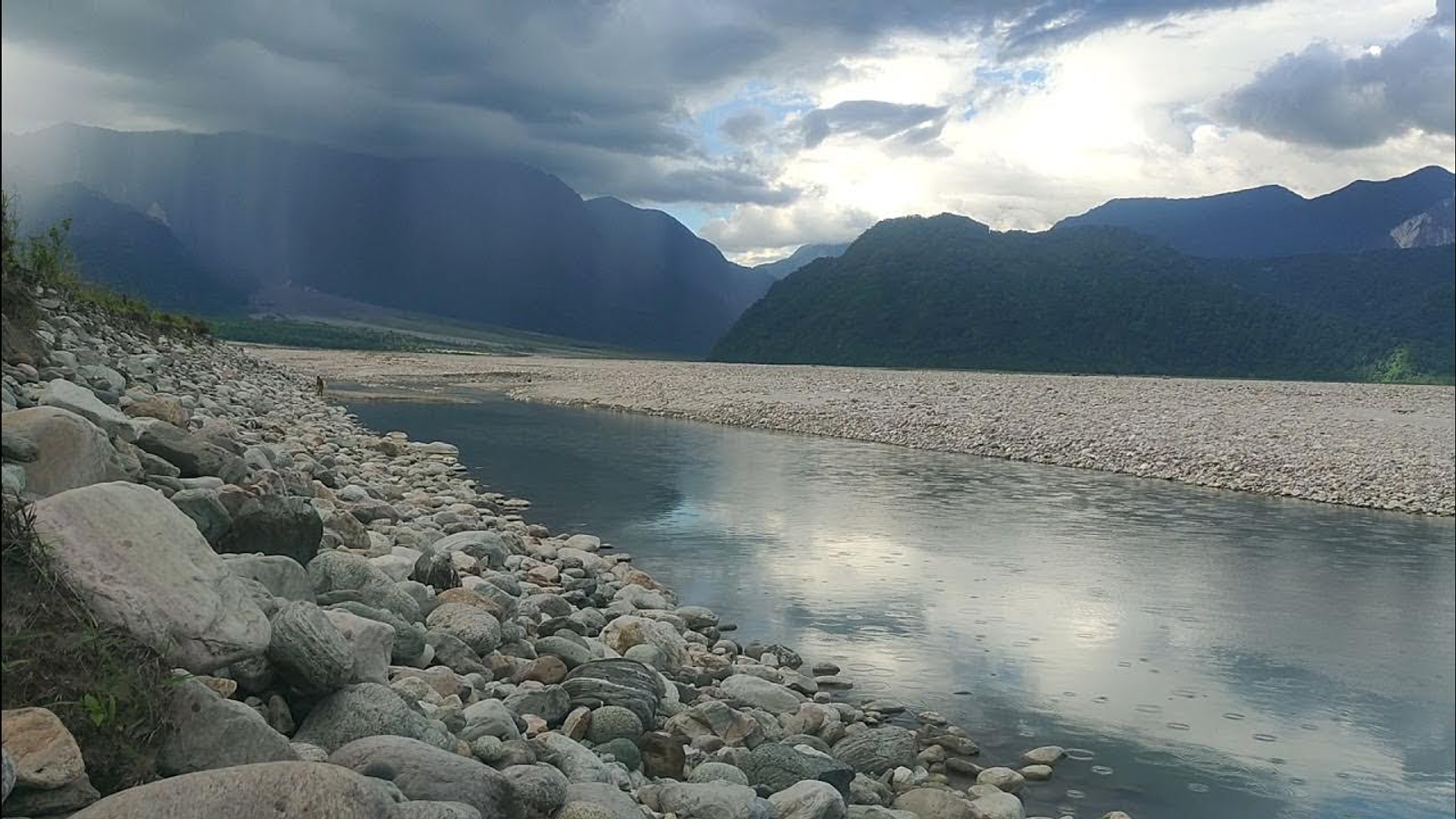 Panoramic view of the turquoise Dibang River flowing through massive white boulders at Nizamghat, showcasing the raw beauty and top things to do in Roing, Arunachal Pradesh.