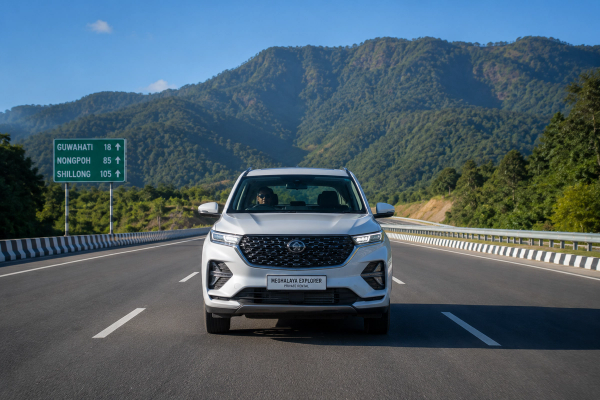 Front view of a private rental SUV driving on the smooth four lane National Highway 6 from Guwahati towards the Meghalaya hills under a clear blue sky
