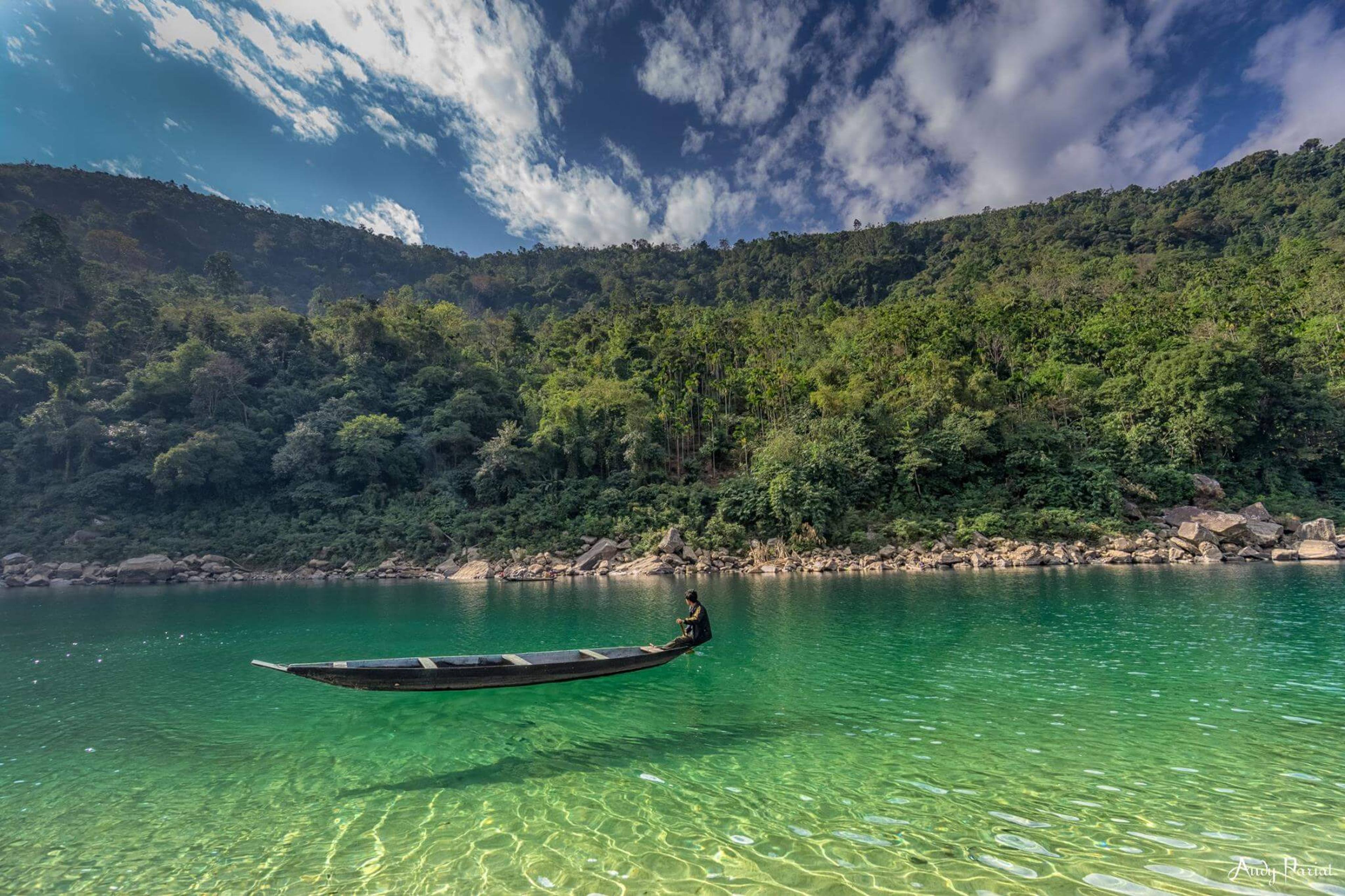 A single boat on the transparent water at Dawki