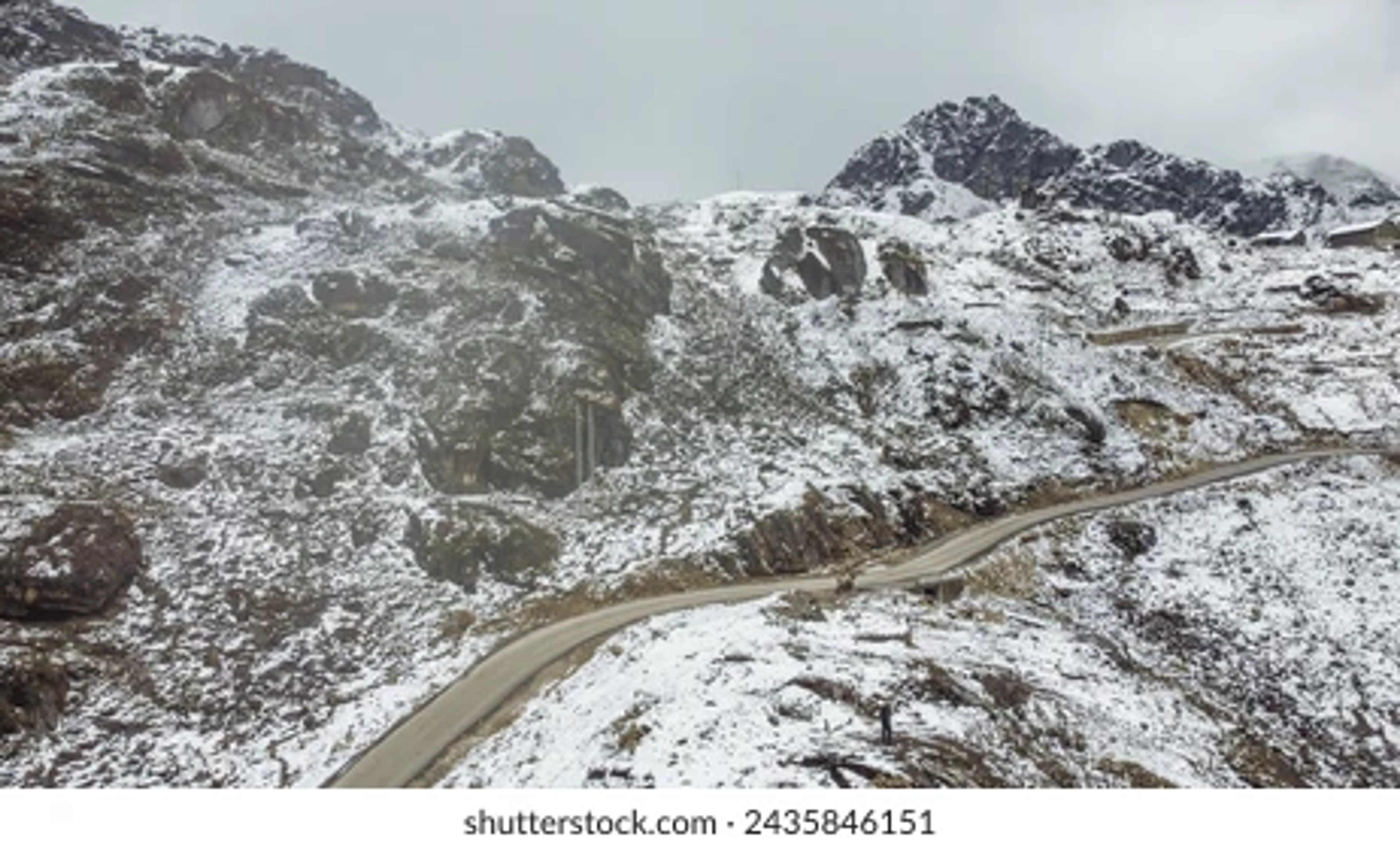 : The winding Trans-Arunachal Highway leading towards Tawang with Himalayan peaks in the background.]