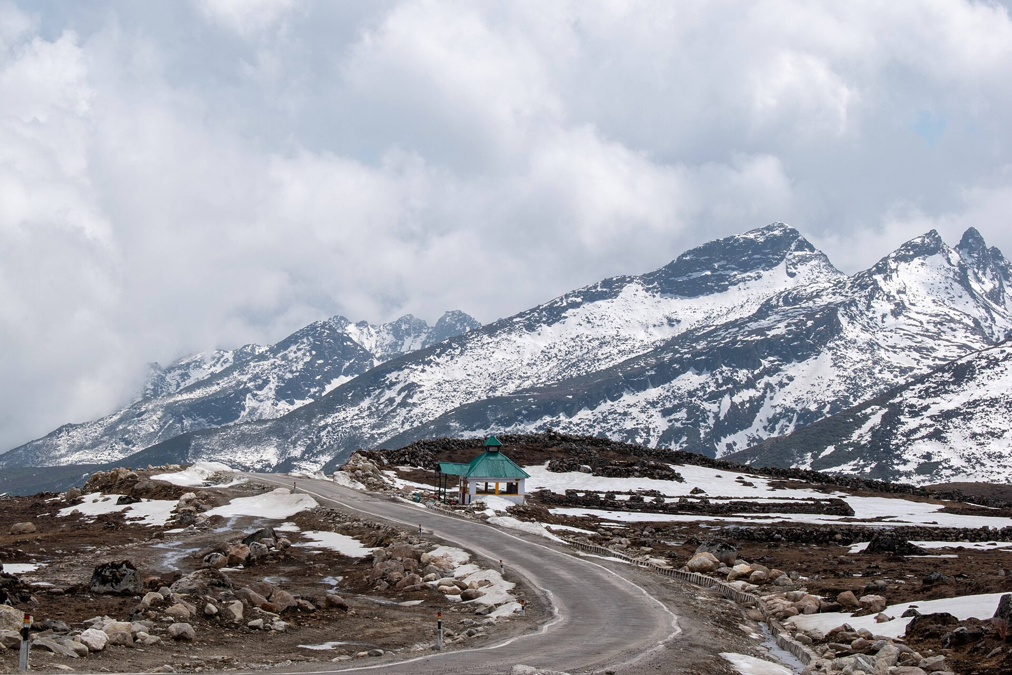 A winding mountain road with snow on the peaks near Bum La Pass