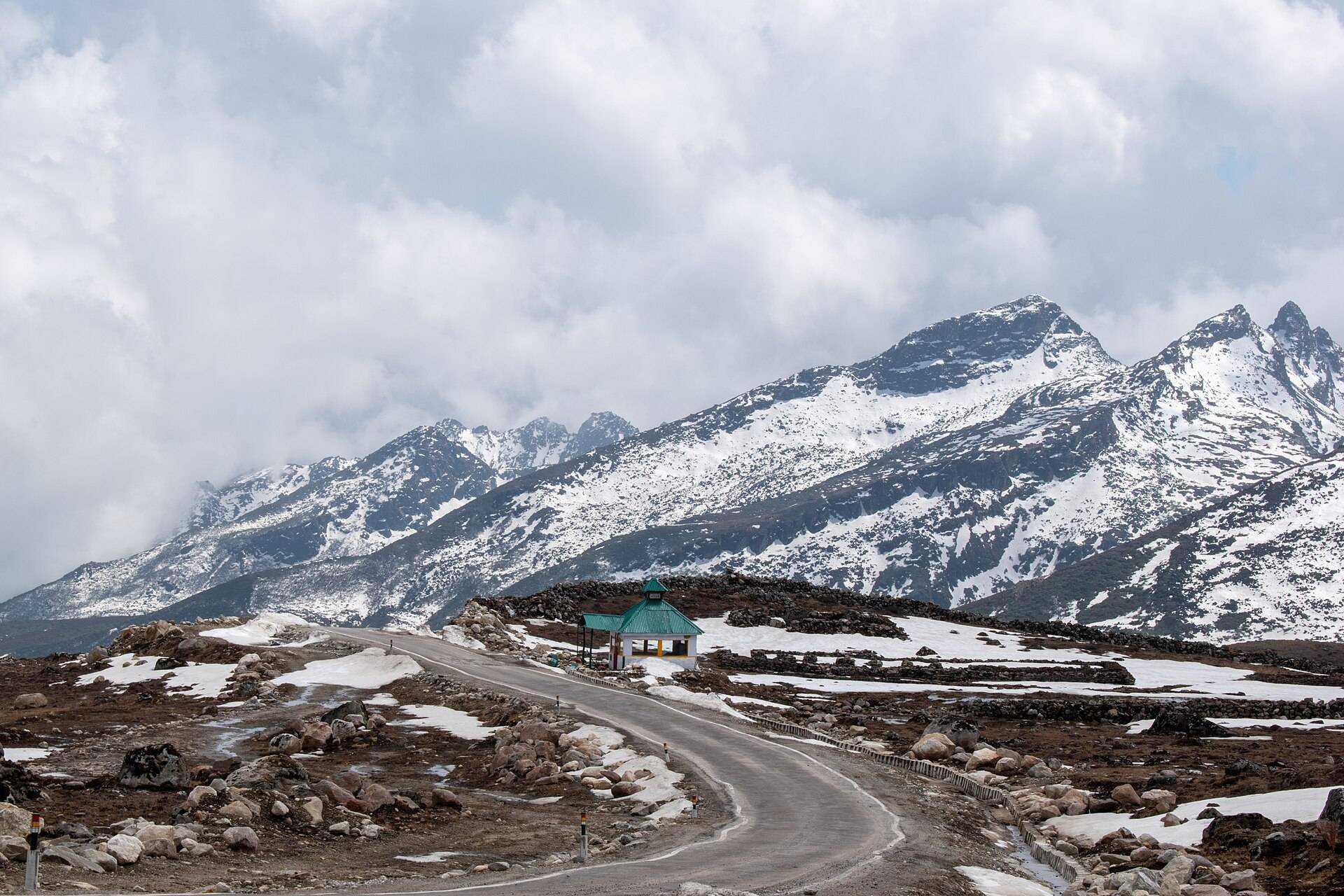 A winding mountain road with snow on the peaks near Bum La Pass