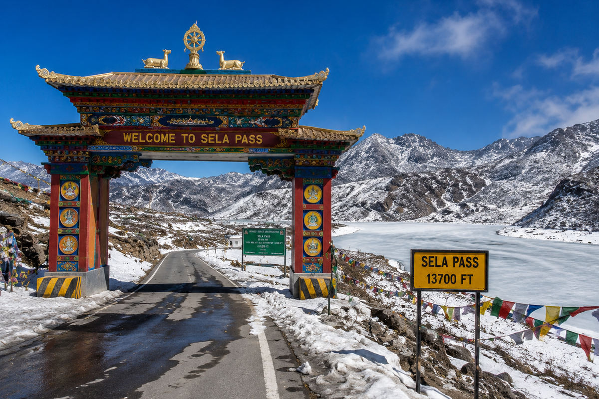 The high-altitude gate structure at Sela Pass under clear blue skies, with snow patches surrounding the frozen Sela Lake.