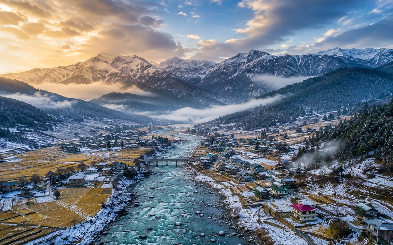 Cinematic aerial view of Dirang Valley in Arunachal Pradesh with mountains and river.