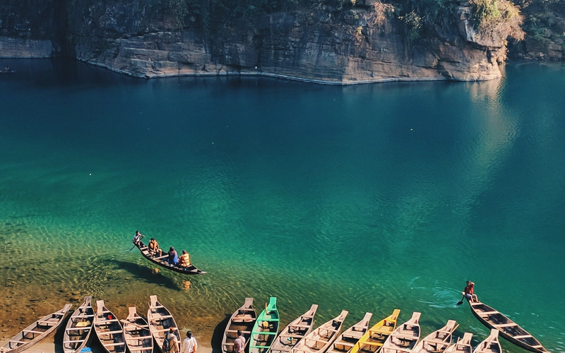 Crystal-clear Umngot River in Dawki, Meghalaya with boats appearing to float on transparent water