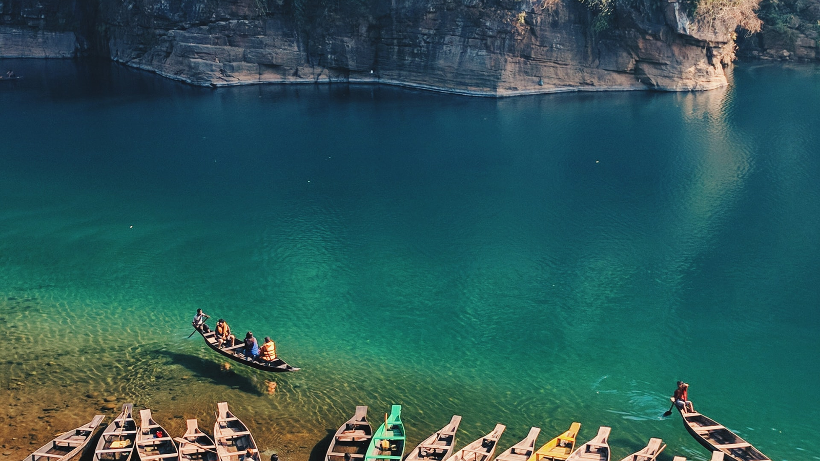 Crystal-clear Umngot River in Dawki, Meghalaya with boats appearing to float on transparent water
