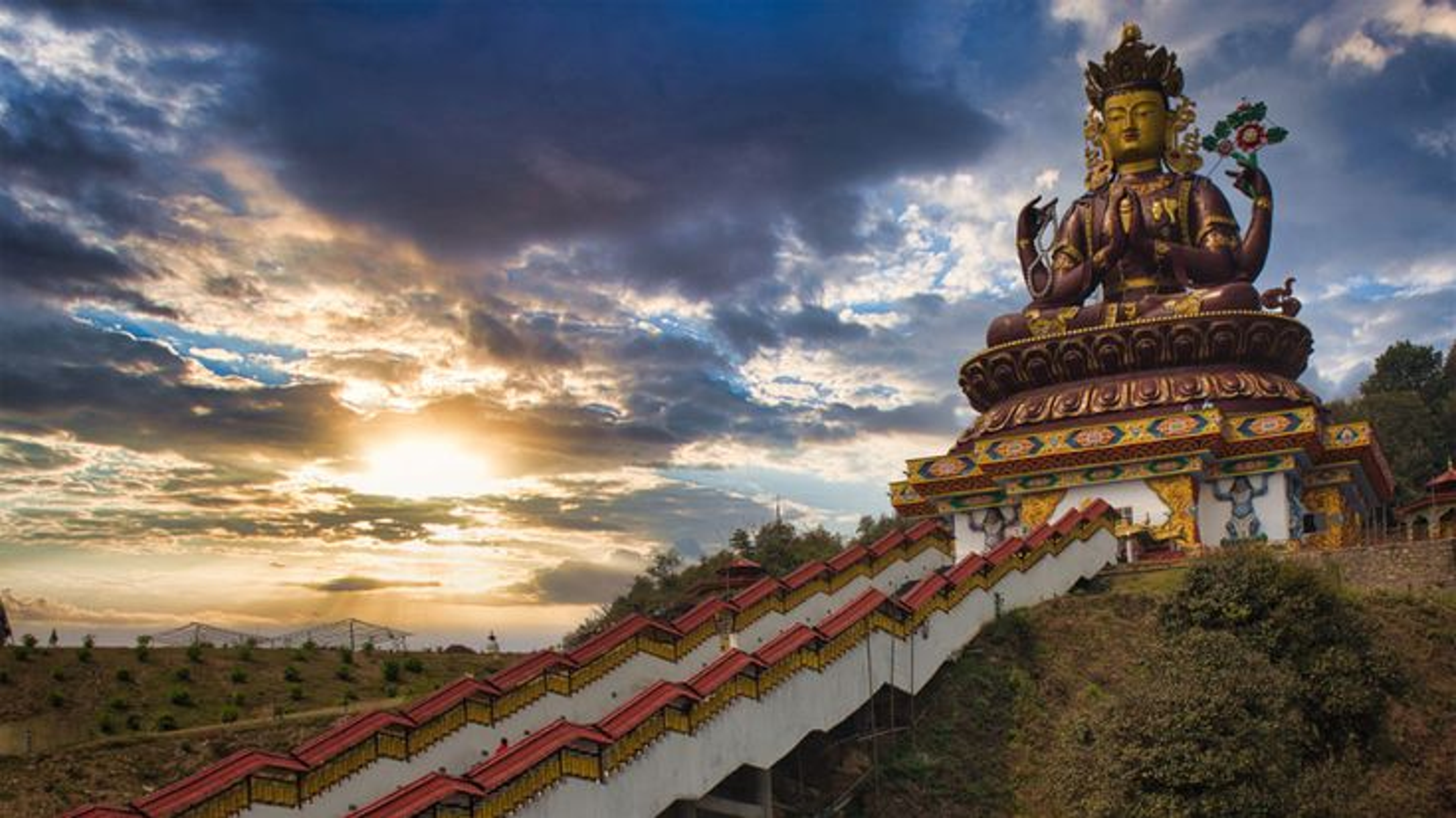 137 feet tall golden Chenrezig Statue Avalokiteshvara in Pelling Sikkim with prayer wheels and Himalayas.