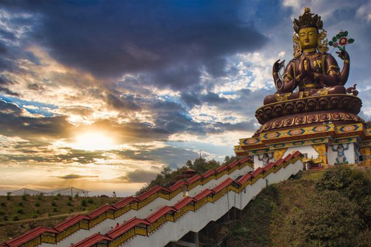 137 feet tall golden Chenrezig Statue Avalokiteshvara in Pelling Sikkim with prayer wheels and Himalayas.
