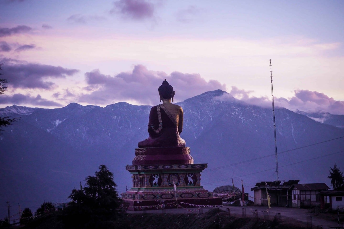 40-foot seated Buddha statue in Tawang overlooking the misty mountain valley at sunset.