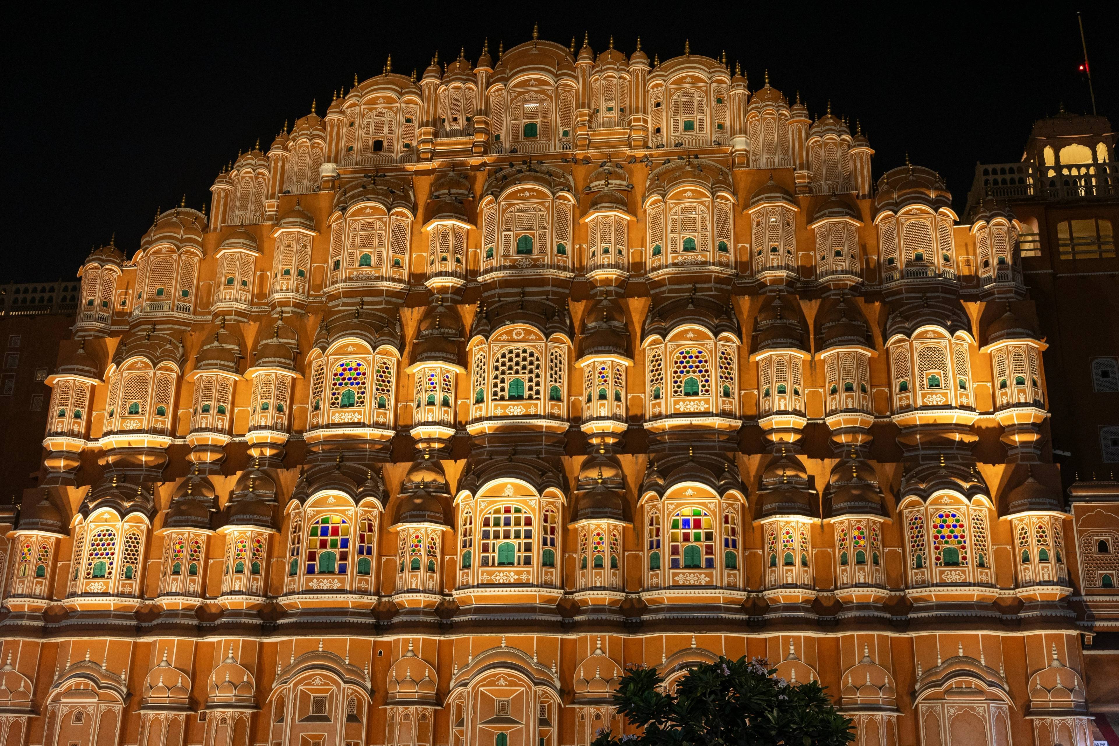 Hawa Mahal in Jaipur lit up at night, its honeycomb of windows glowing gold