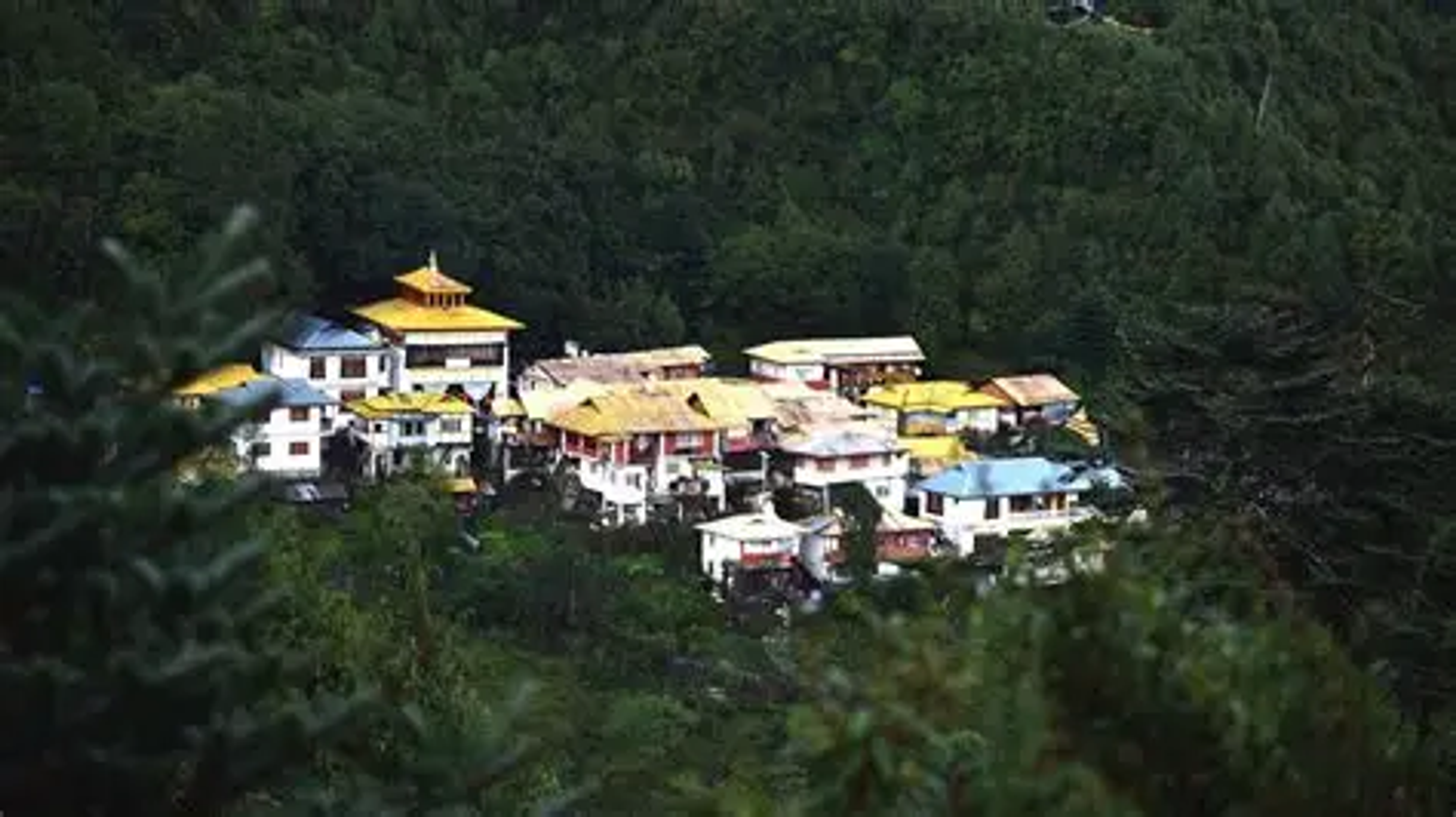 Buddhist nuns in maroon robes at the Brahma-dung-chung Ani Gompa, overlooking the panoramic Tawang Valley.