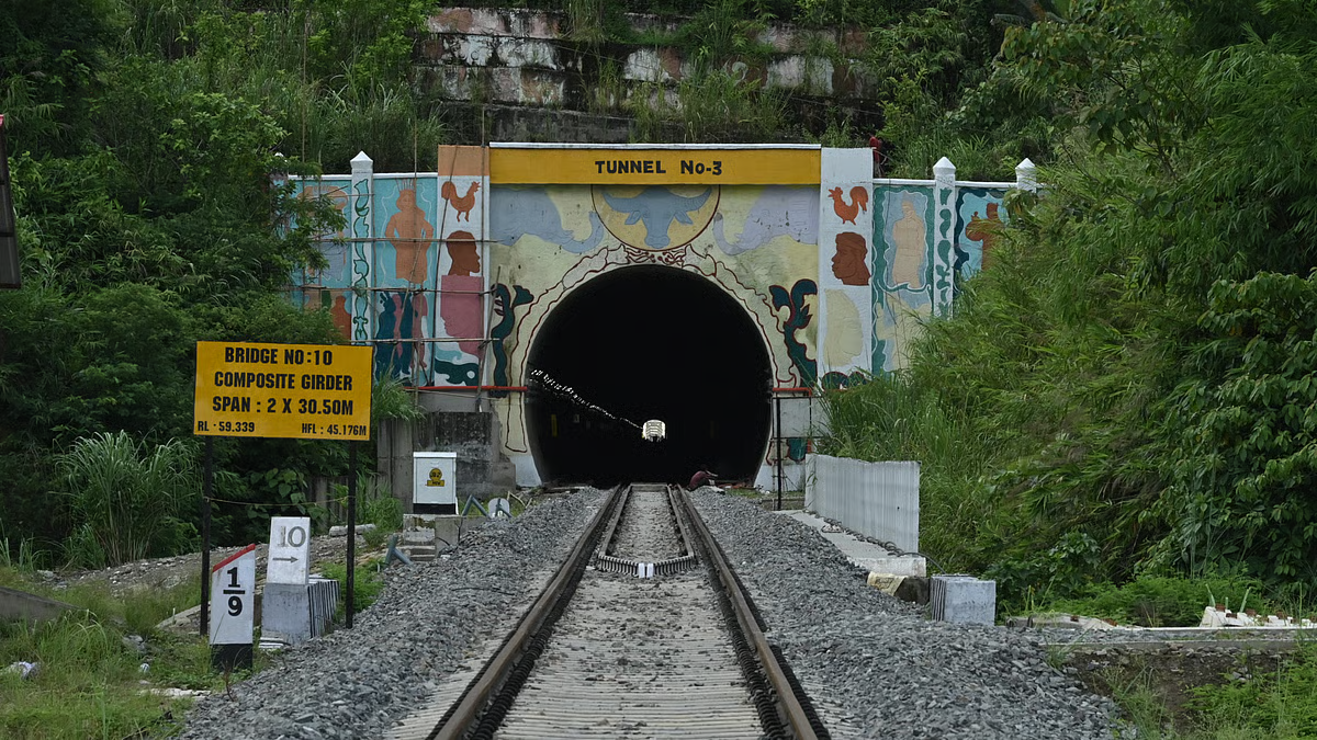 Passenger train coming out of a tunnel on the Bairabi Sairang railway line in the green Mizo hills