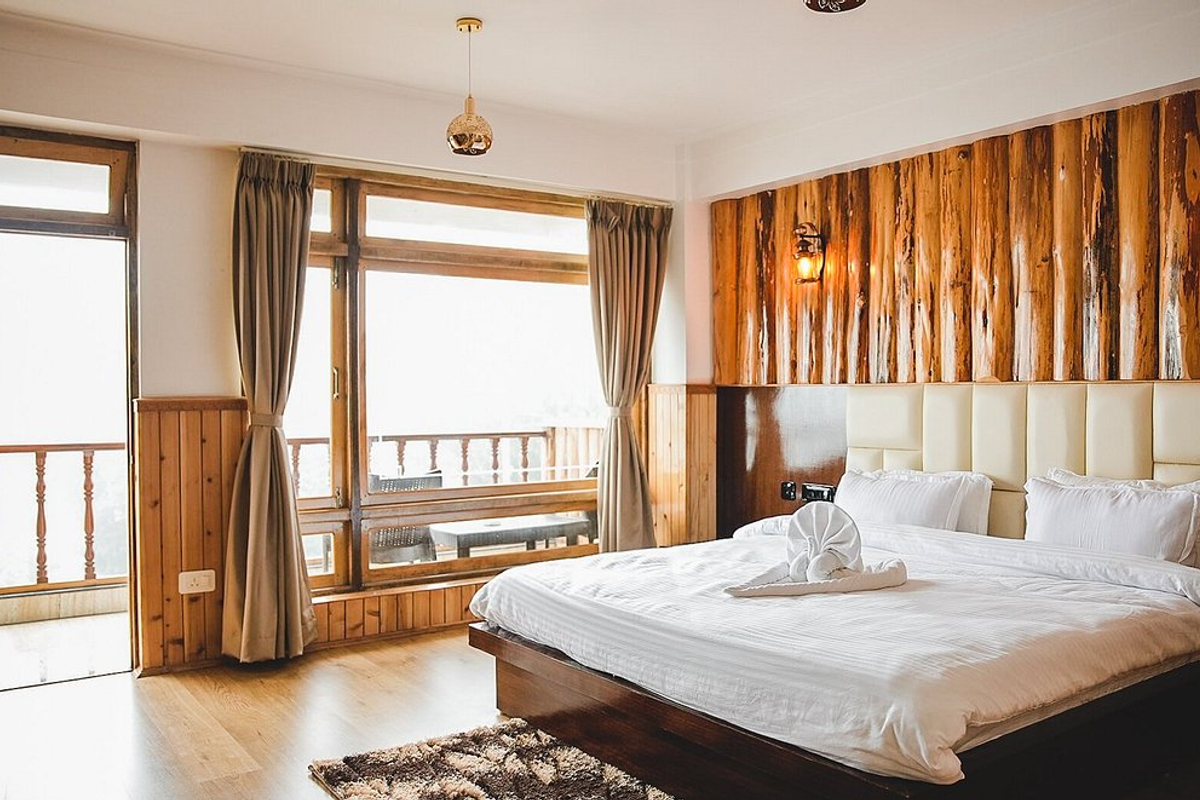 A cozy traditional wooden homestay room in West Sikkim with a direct view of Mount Kanchenjunga through the window."