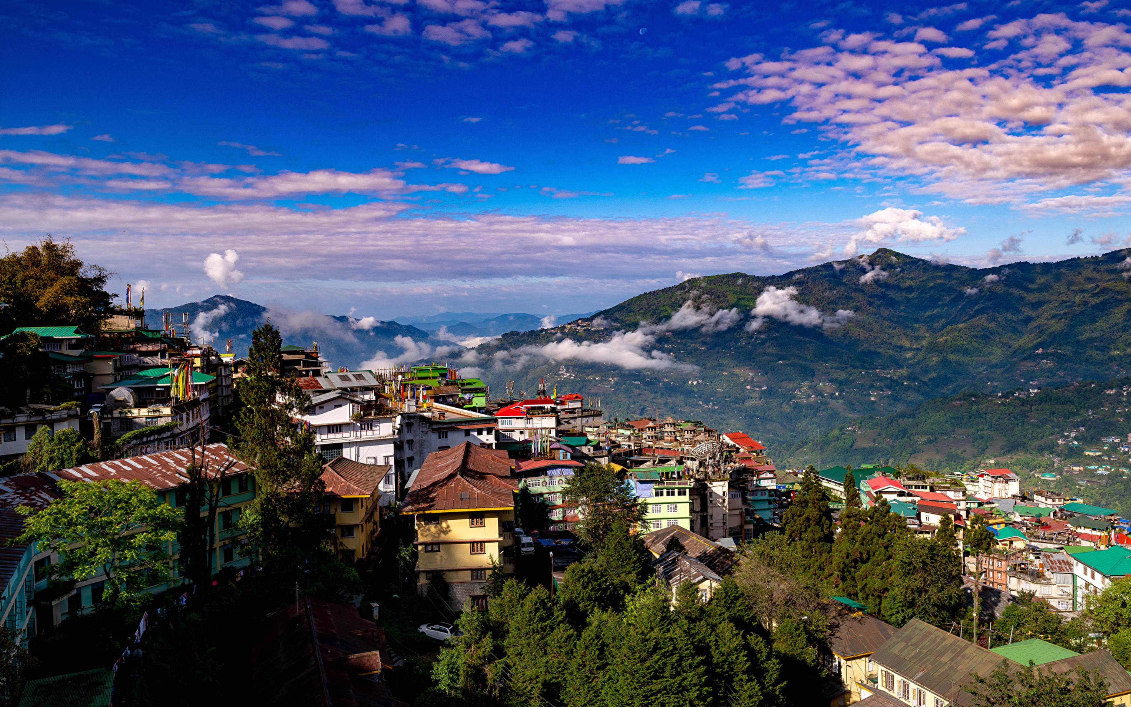 Gangtok's rooftops and the hills of East Sikkim under a blue sky