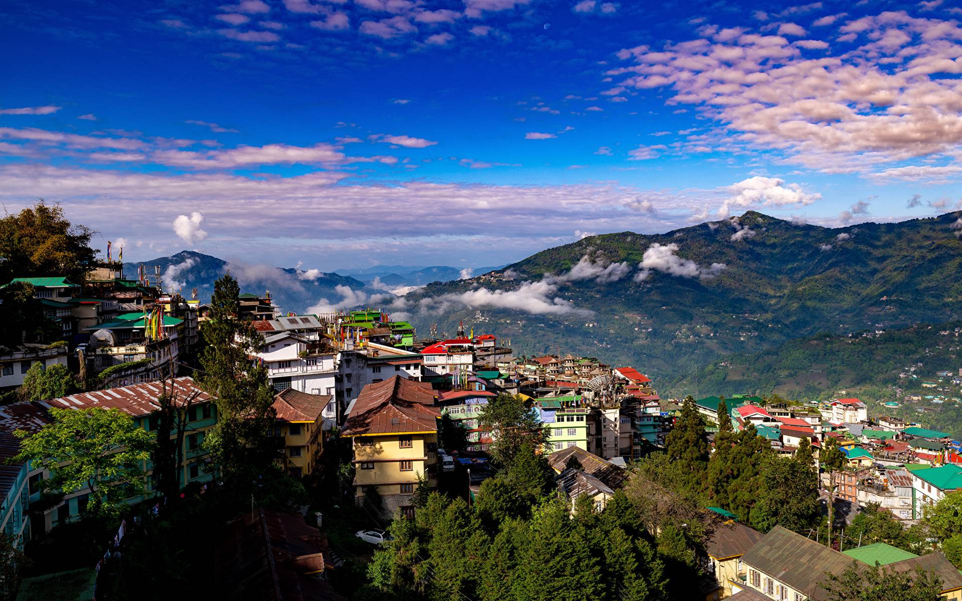 Gangtok's rooftops and the hills of East Sikkim under a blue sky