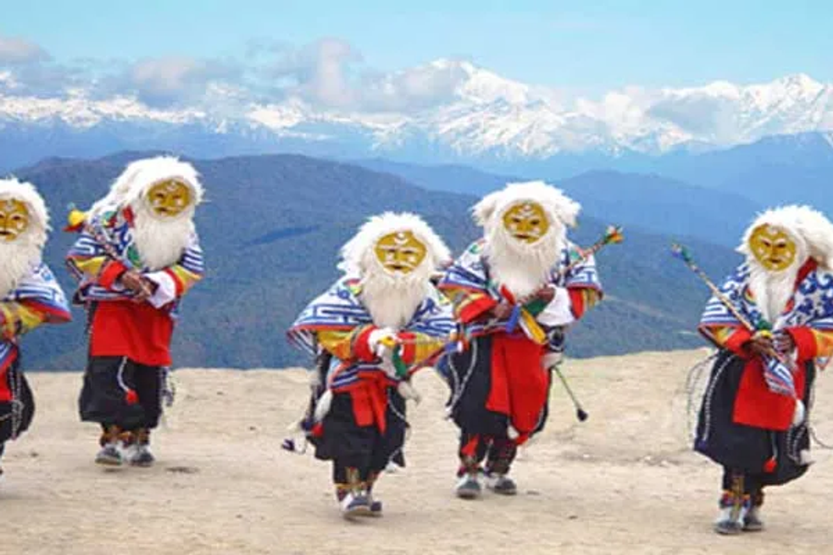 Monpa tribesmen in traditional colorful masks and silk ethnic wear performing a ritual dance in Tawang.
