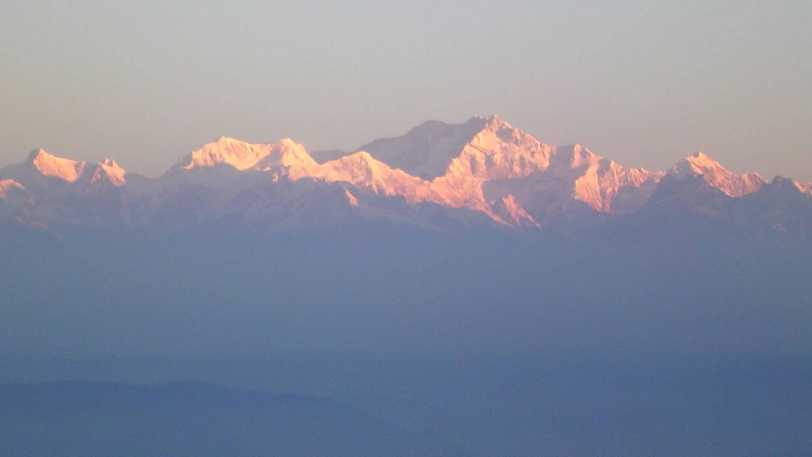 The peaks of Kangchenjunga lit pink at sunrise, seen from Tiger Hill near Darjeeling