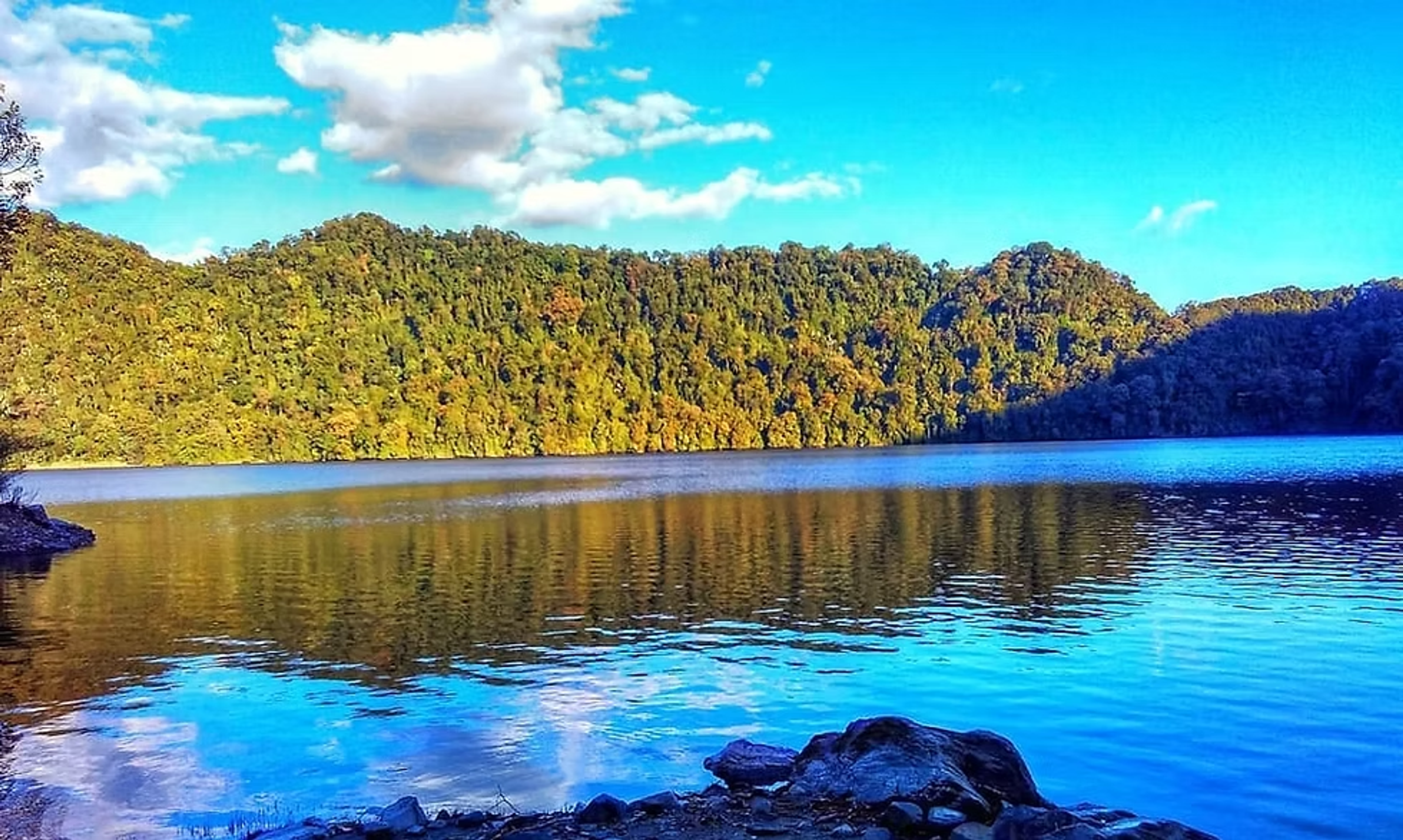 Crystal clear water of Mehao Lake surrounded by dense virgin forests in Mehao Wildlife Sanctuary.