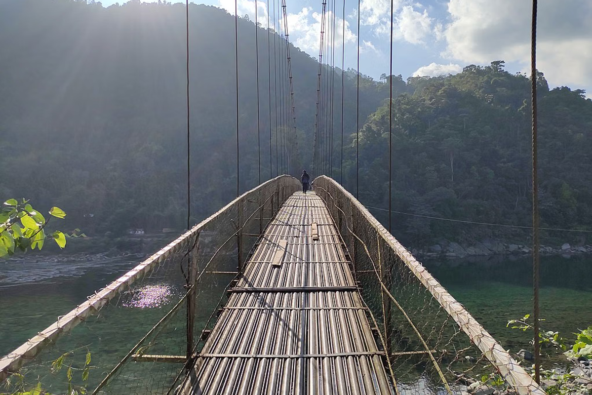 The Dawki Suspension Bridge stretching over the turquoise Umngot River offering a top-down view of the crystal-clear water below
