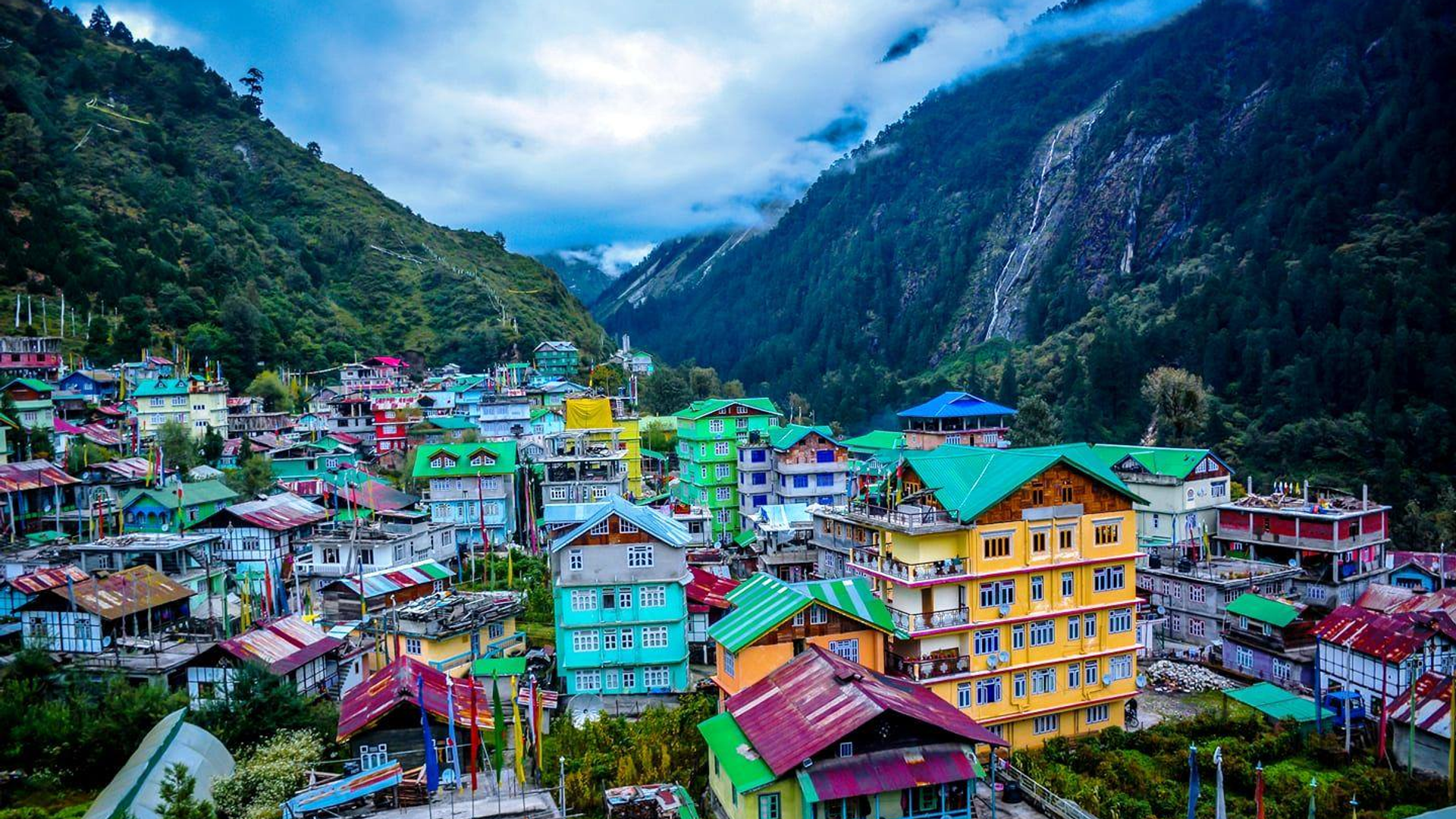 Lachung village in North Sikkim with snow-capped Himalayan peaks, colorful houses and rhododendron forests near Yumthang Valley.